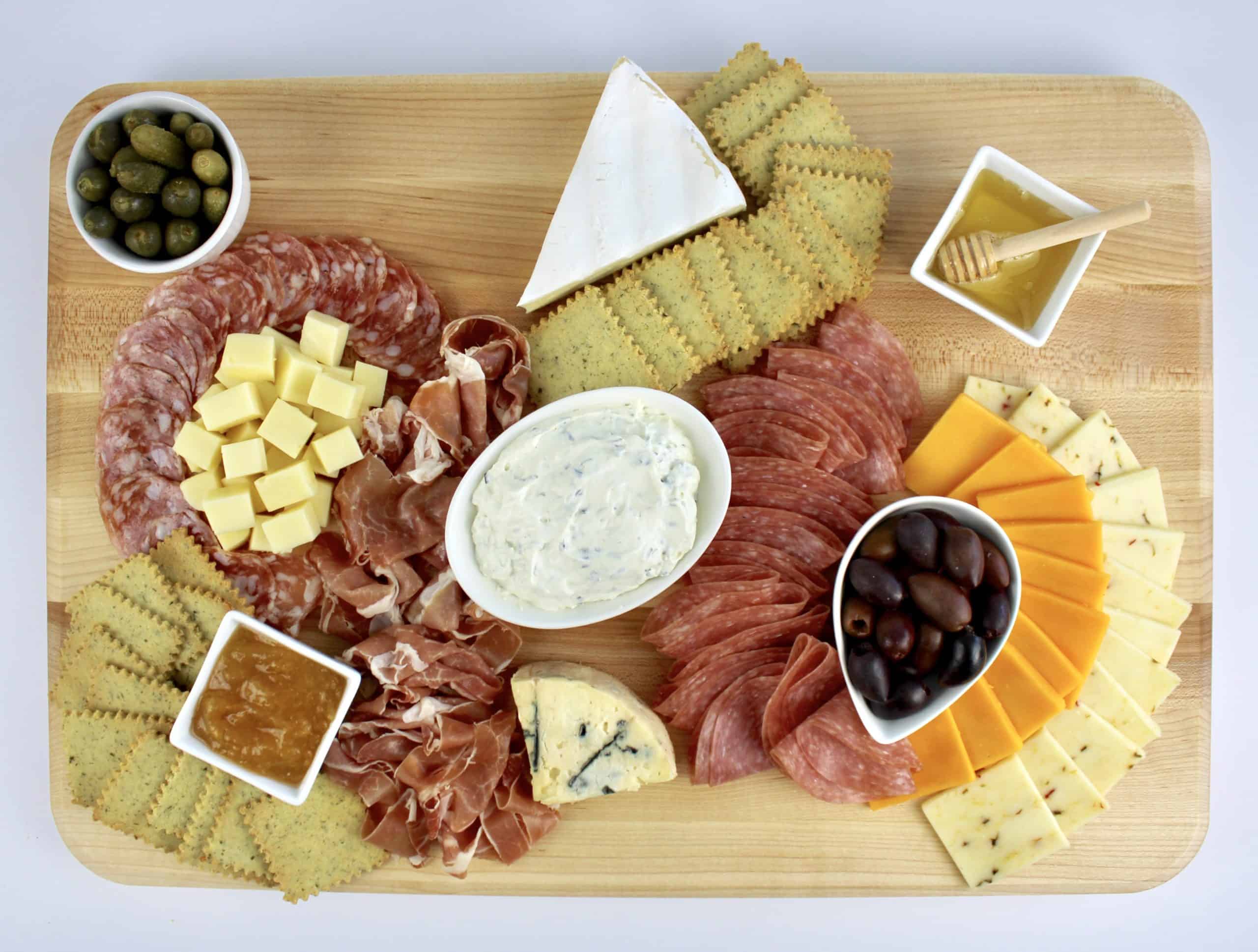 cheese board with meats cheeses and crackers