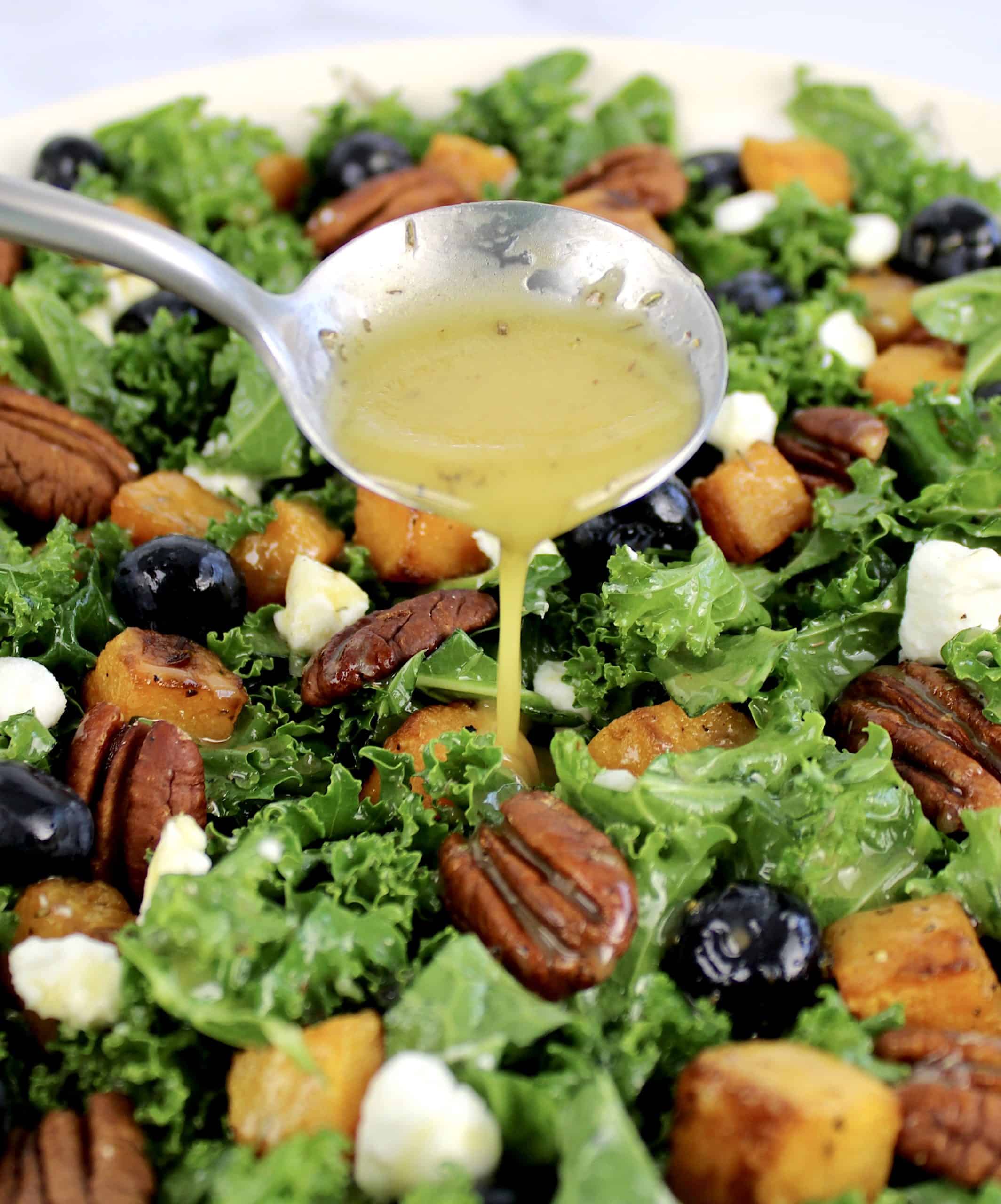 kale salad with dressing being spooned over top