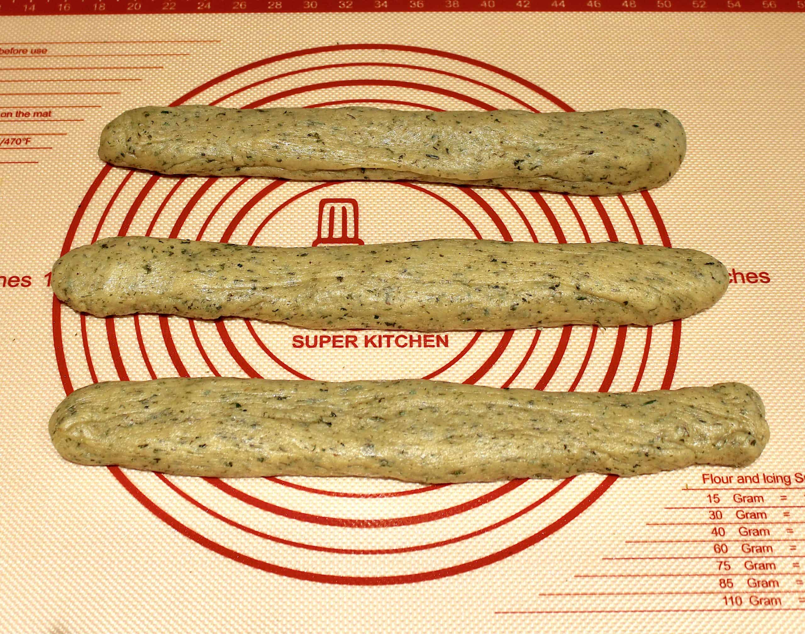 3 logs of herb dough rolled out on Silpat
