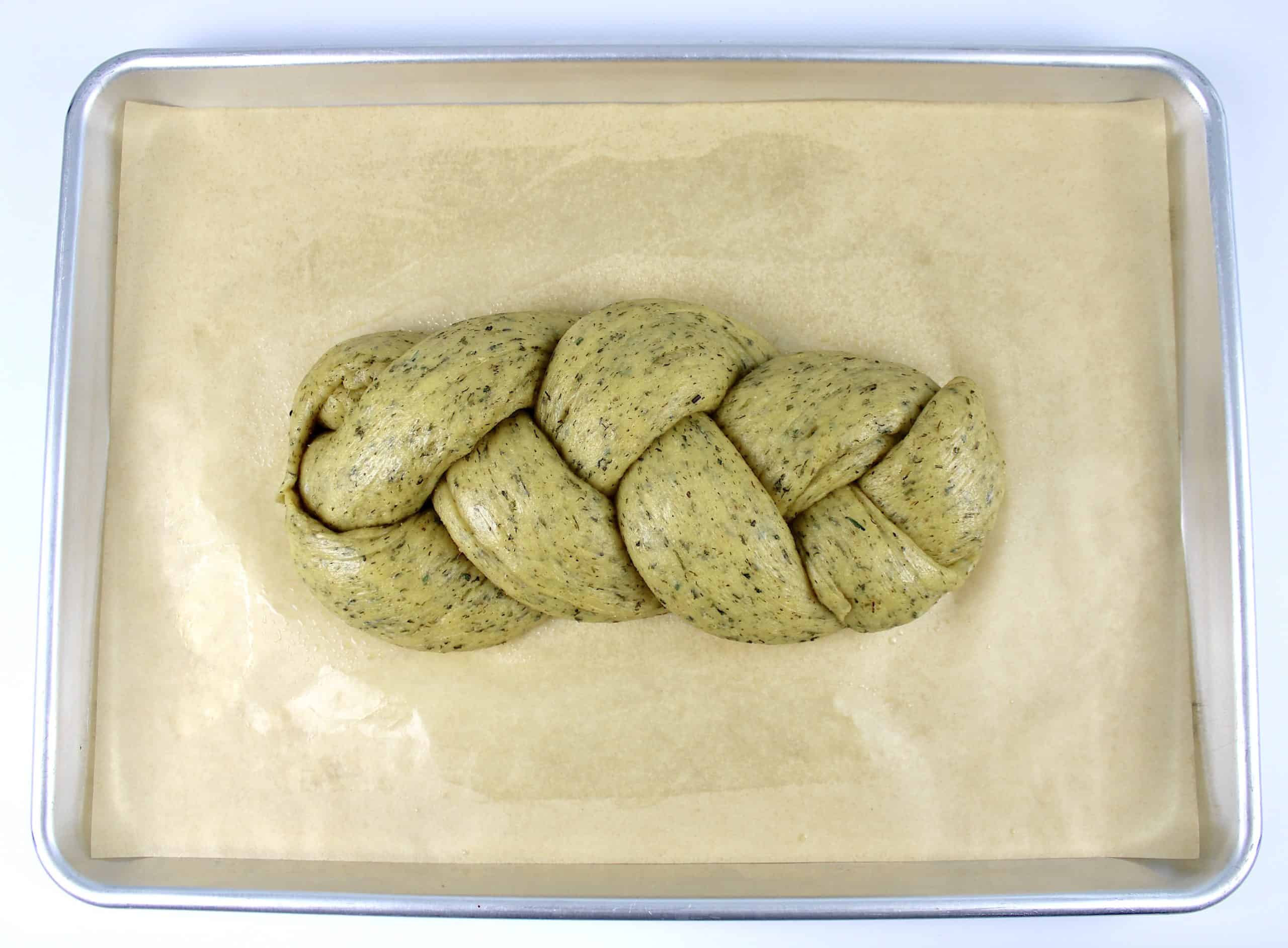 proofed Keto Braided Herb Bread dough unbaked on parchment lined baking sheet