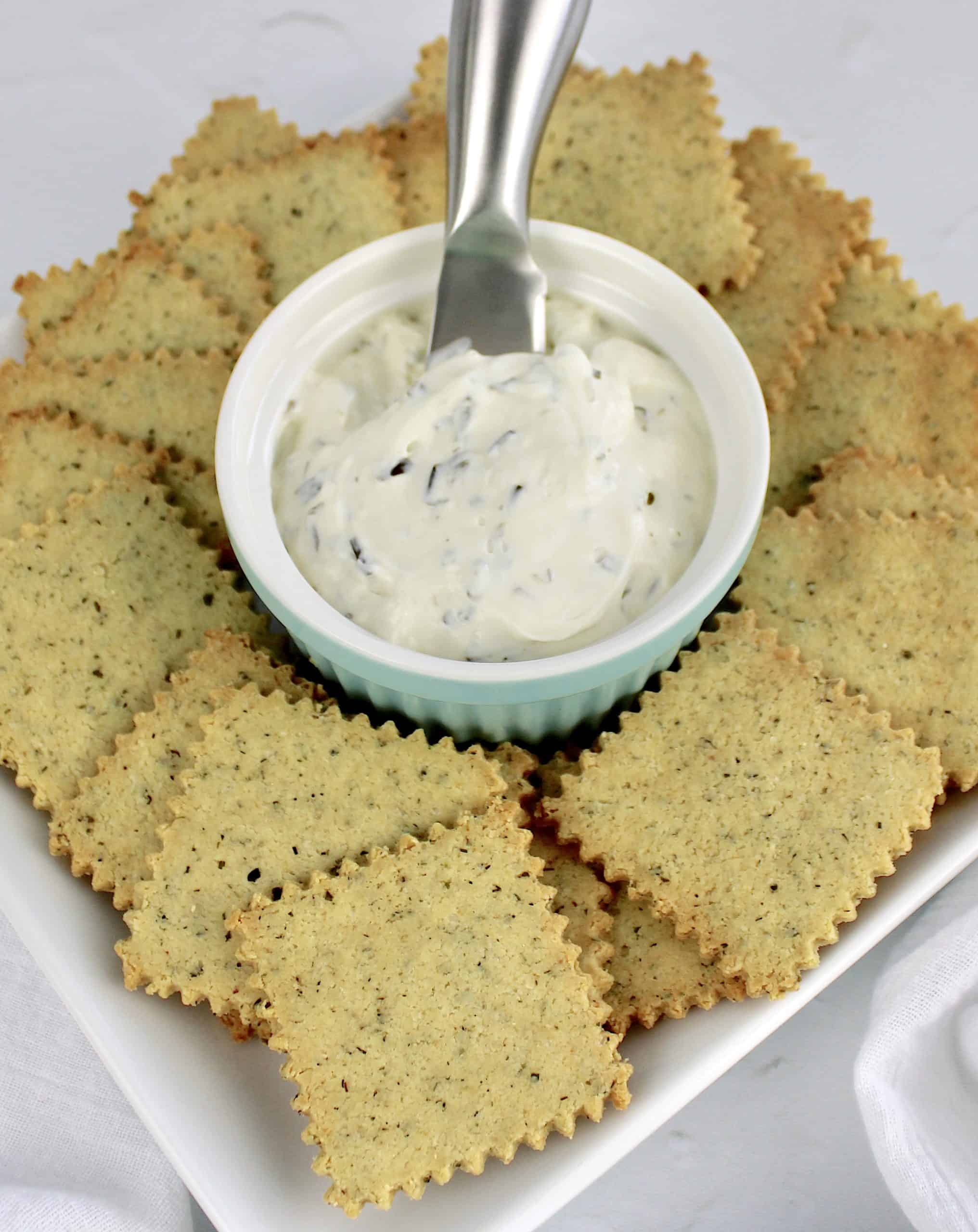 ranch crackers on white plate with cream cheese spread and spreader