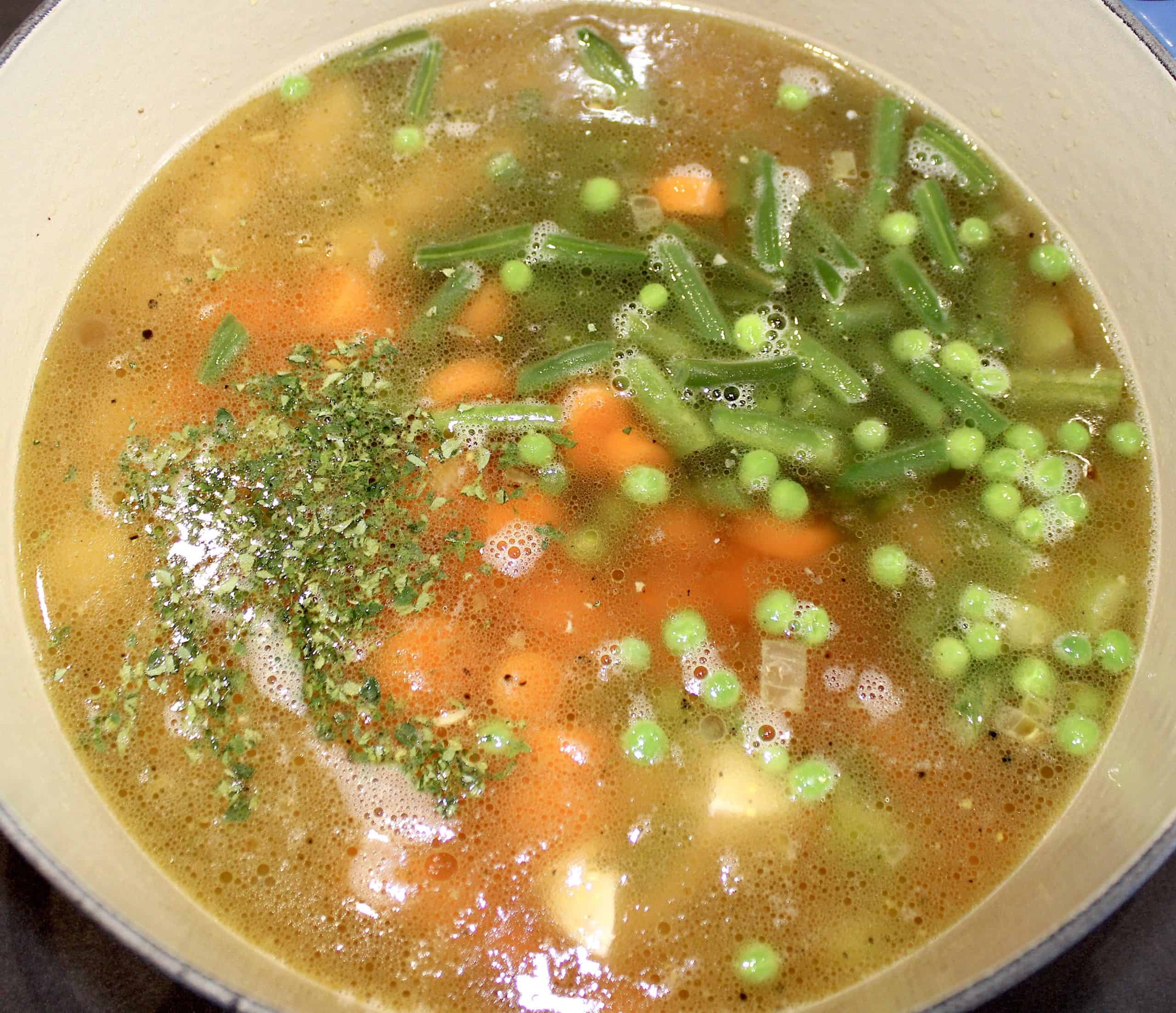 chicken pot pie soup with veggies uncooked in pot