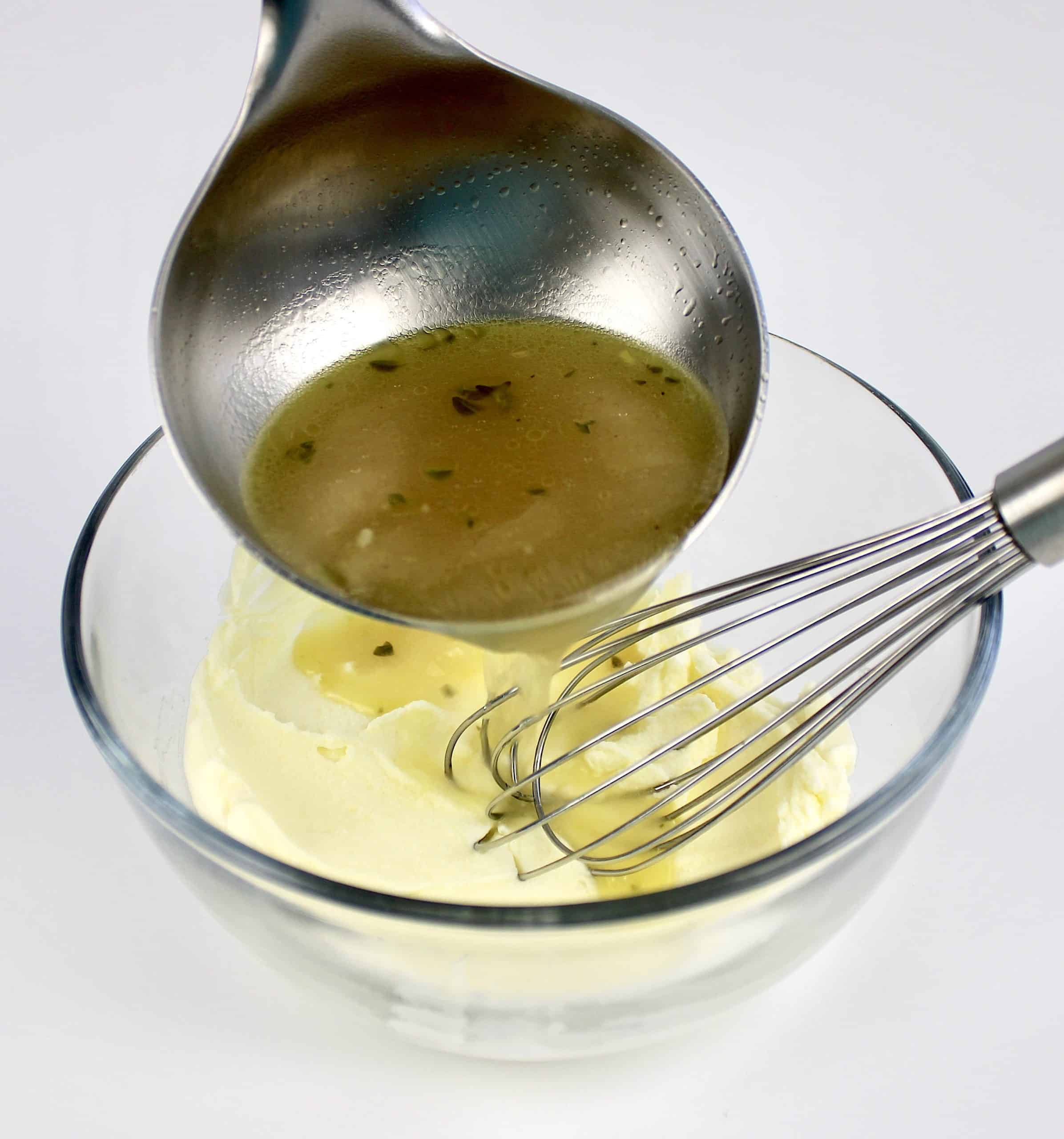 mascarpone in glass bowl with chicken broth being ladled in
