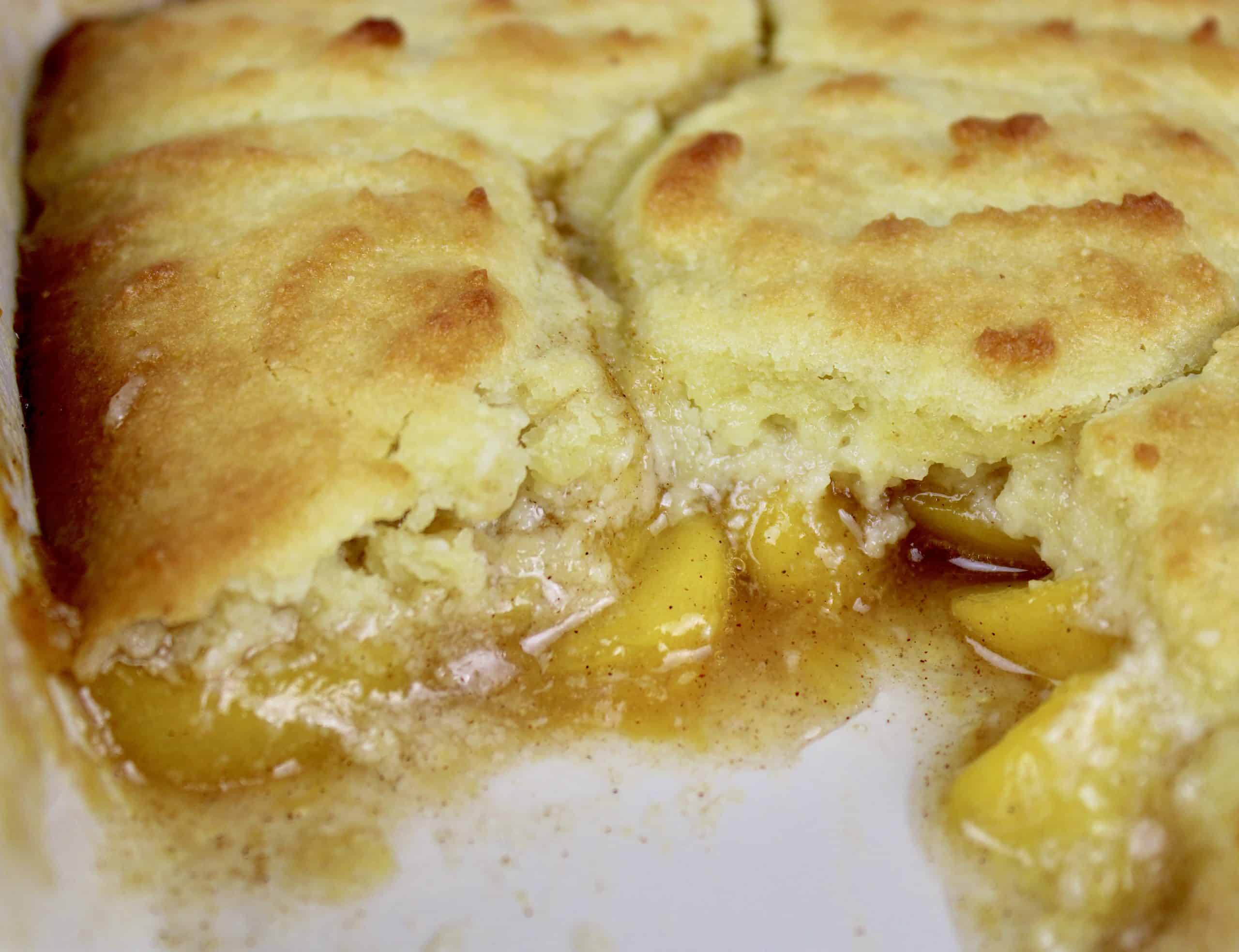 closeup of peach cobbler with piece missing