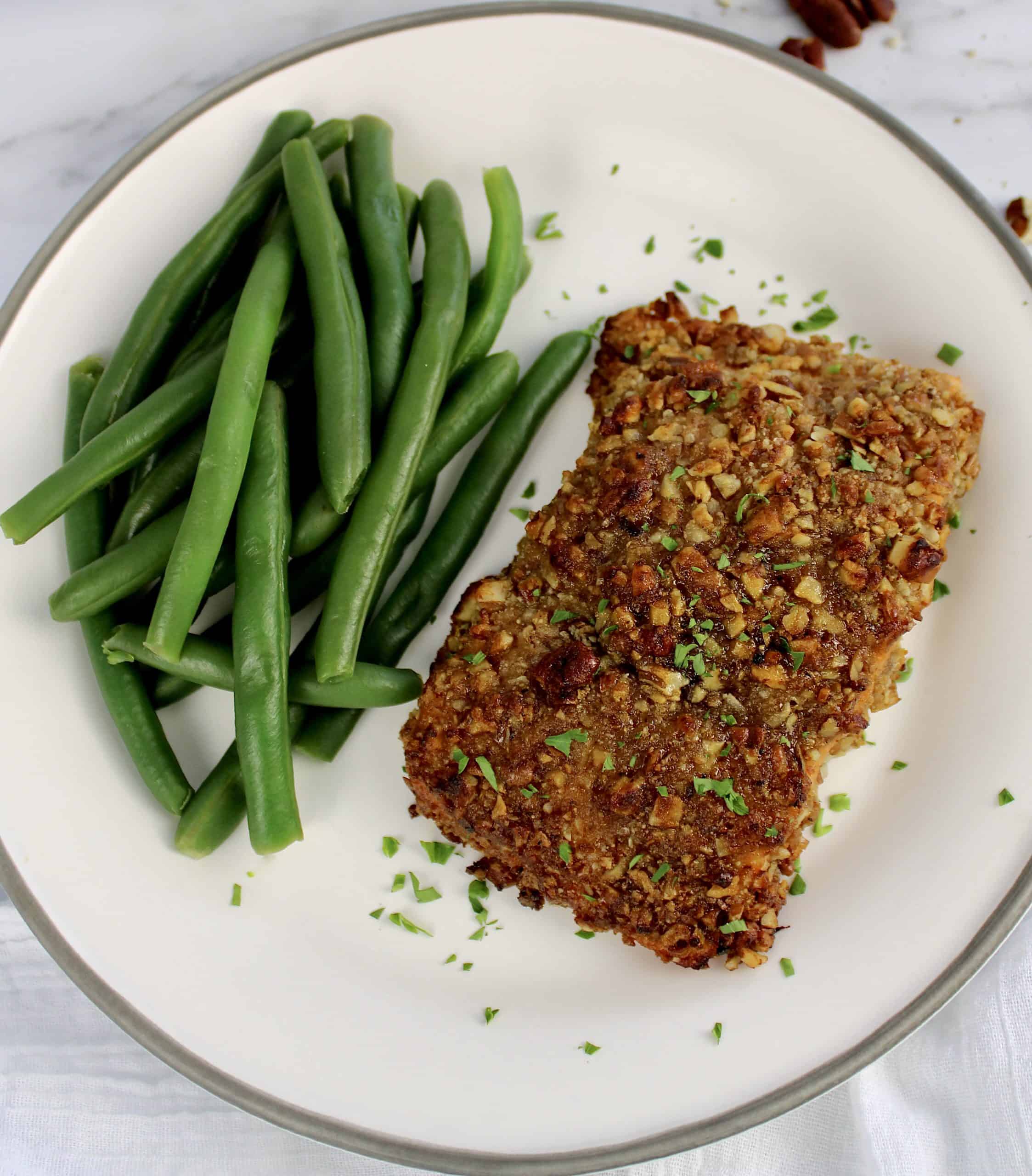 Pecan Crusted Salmon on white plate with green beans on side