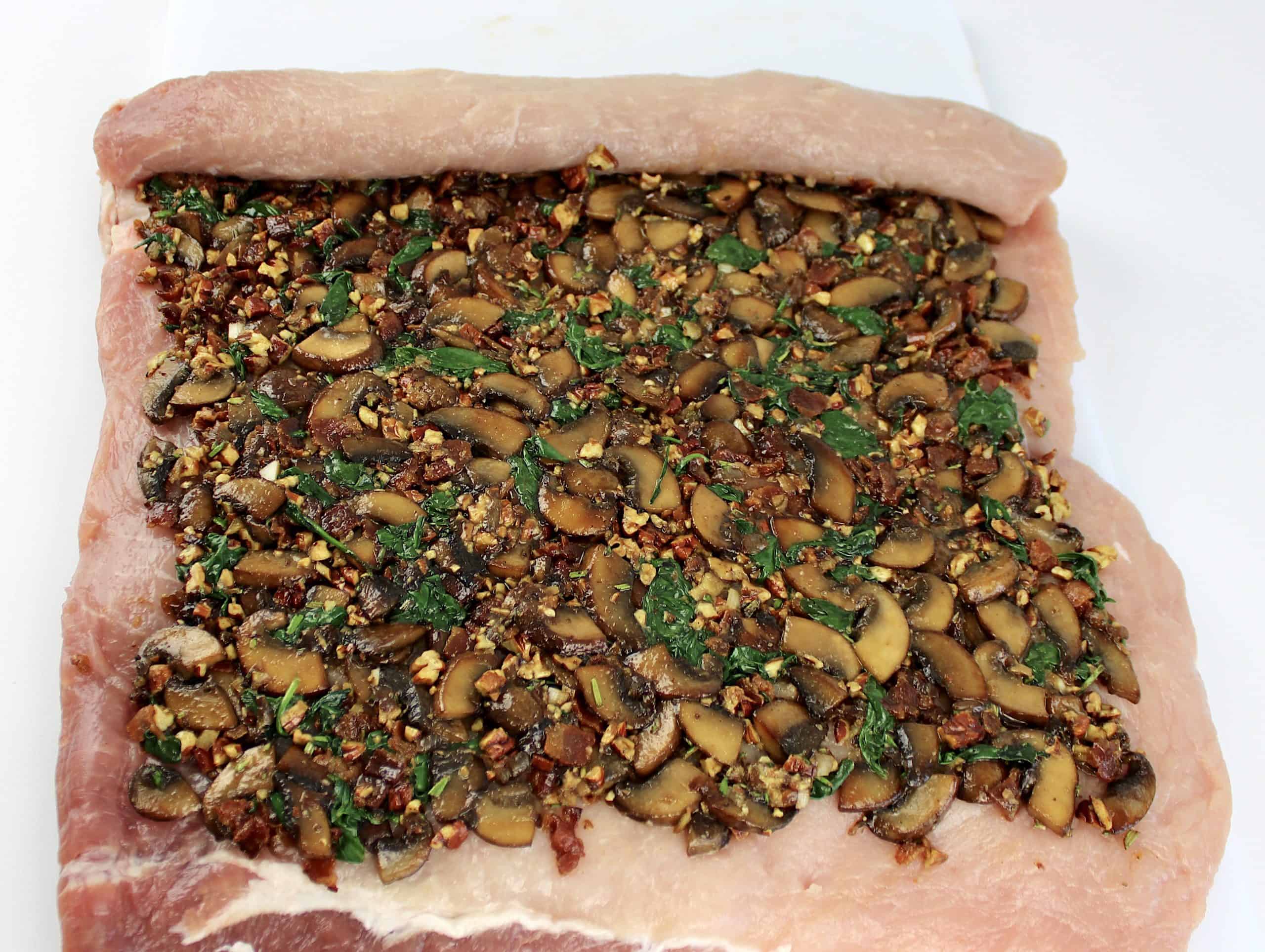 pork loin with stuffing on top being rolled up