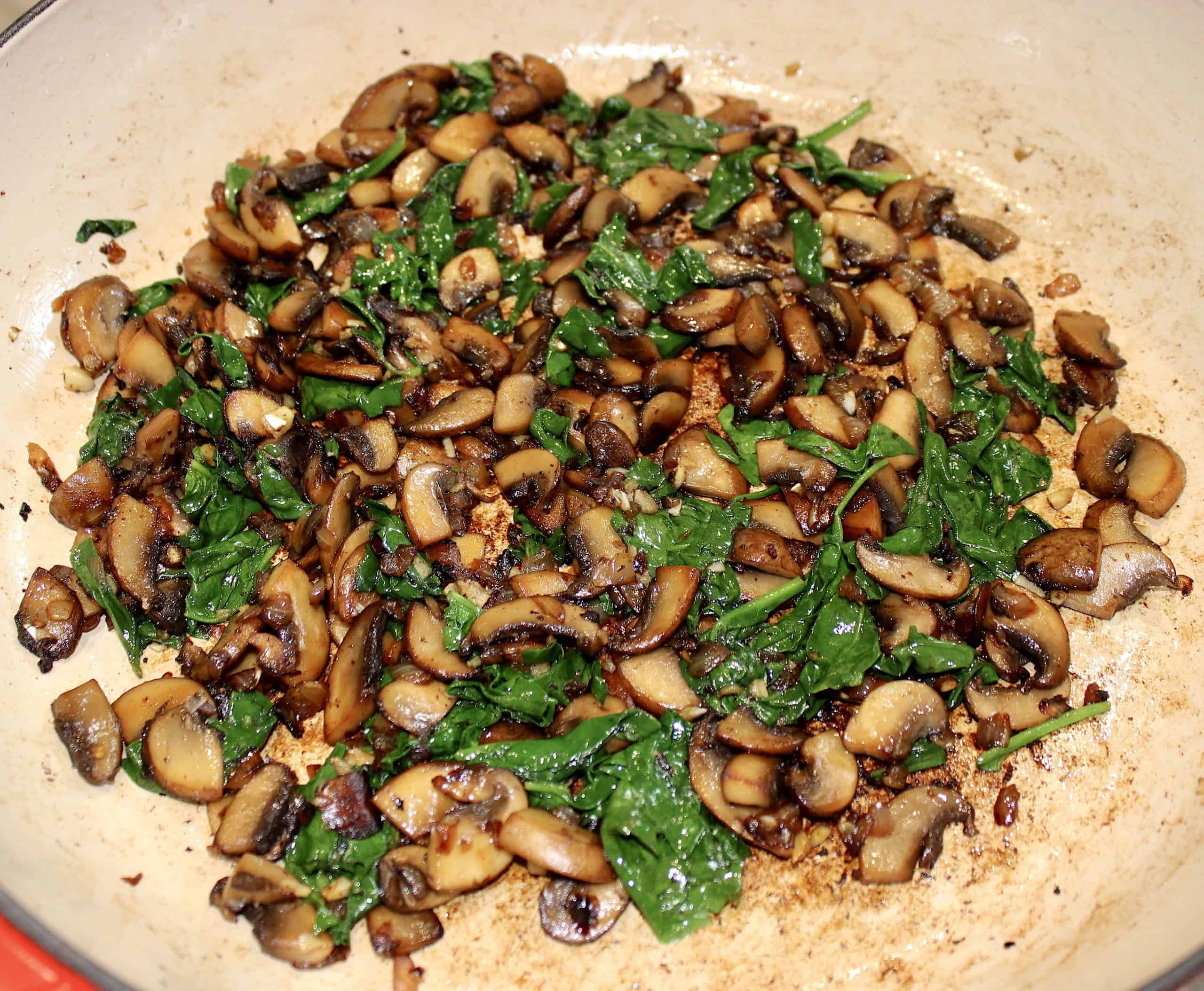 mushrooms onions and spinach sautéed in pan