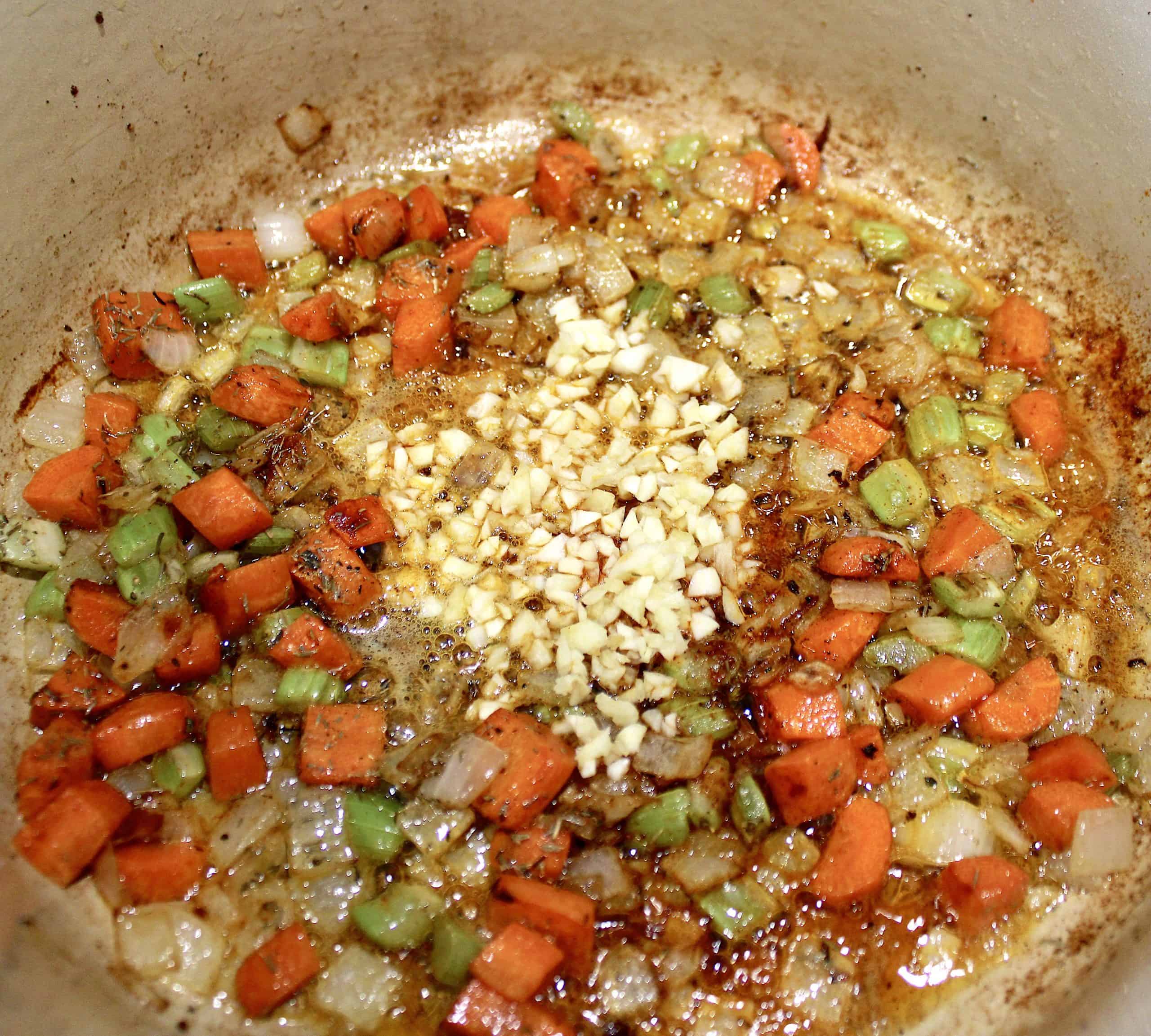 carrots celery onion and garlic cooking in pot