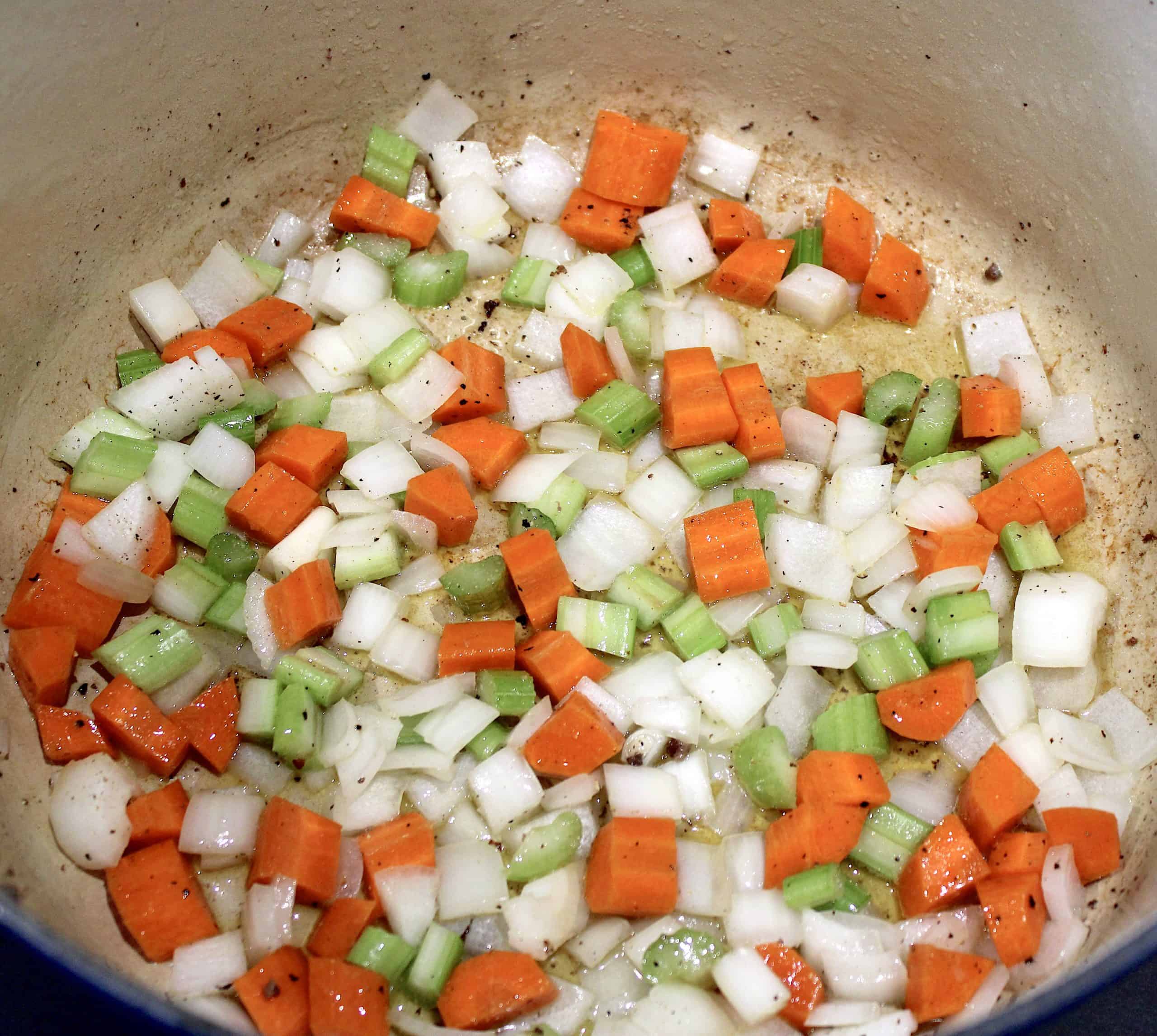 chopped carrots celery onion cooking in pot