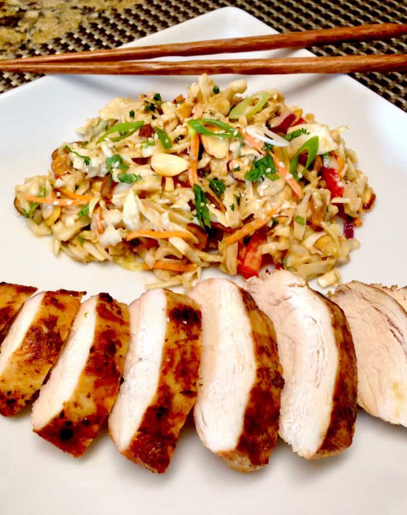 asian grilled chicken sliced on white plate with ginger slaw