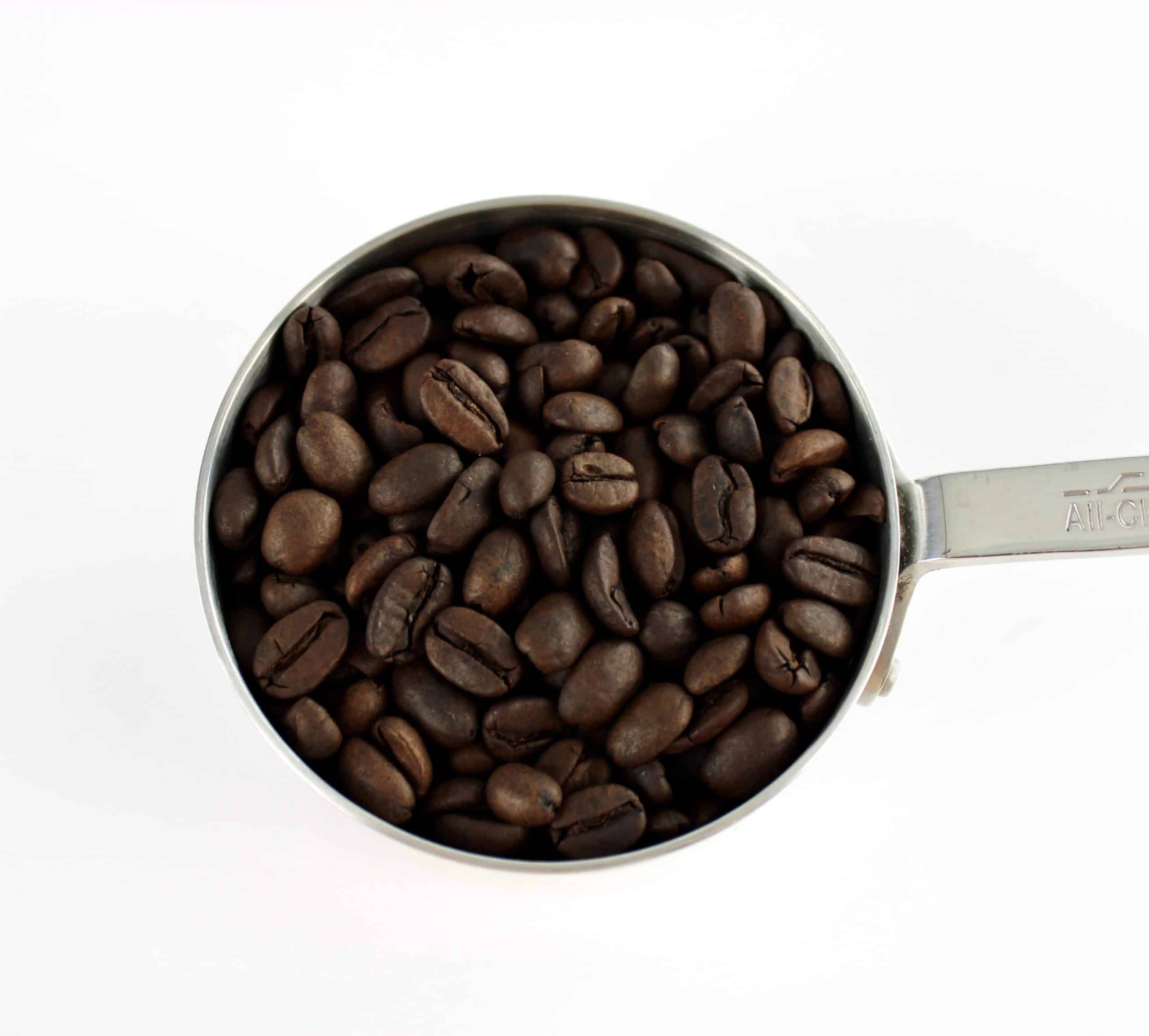 coffee beans in silver measuring cup