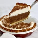 slice of french silk pie on pie server with whip cream on top