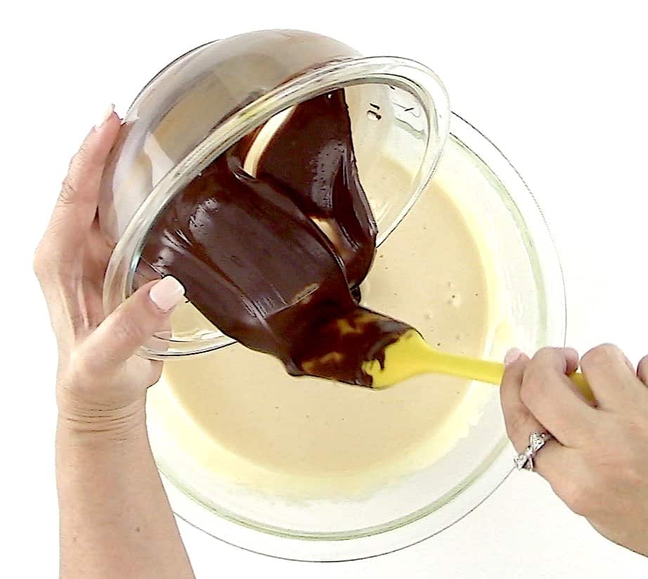 chocolate being poured into custard with yellow spatula