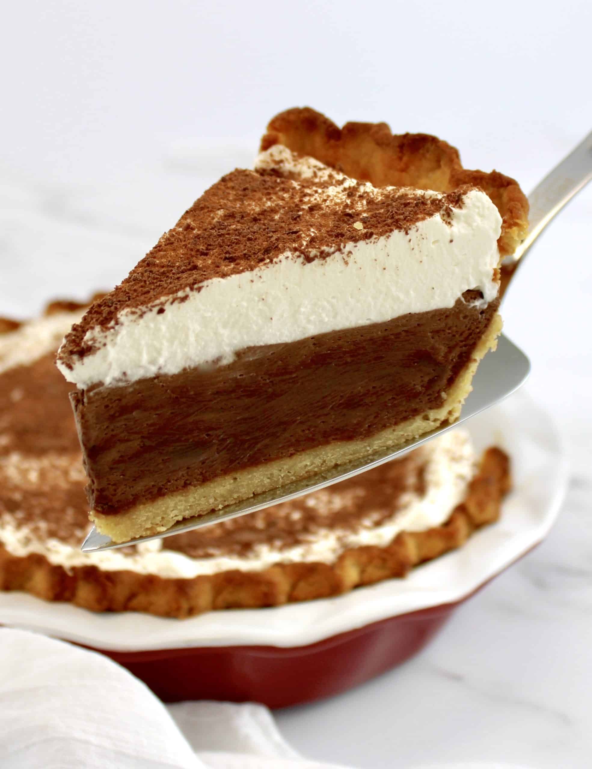 slice of french silk pie on pie server with whip cream on top