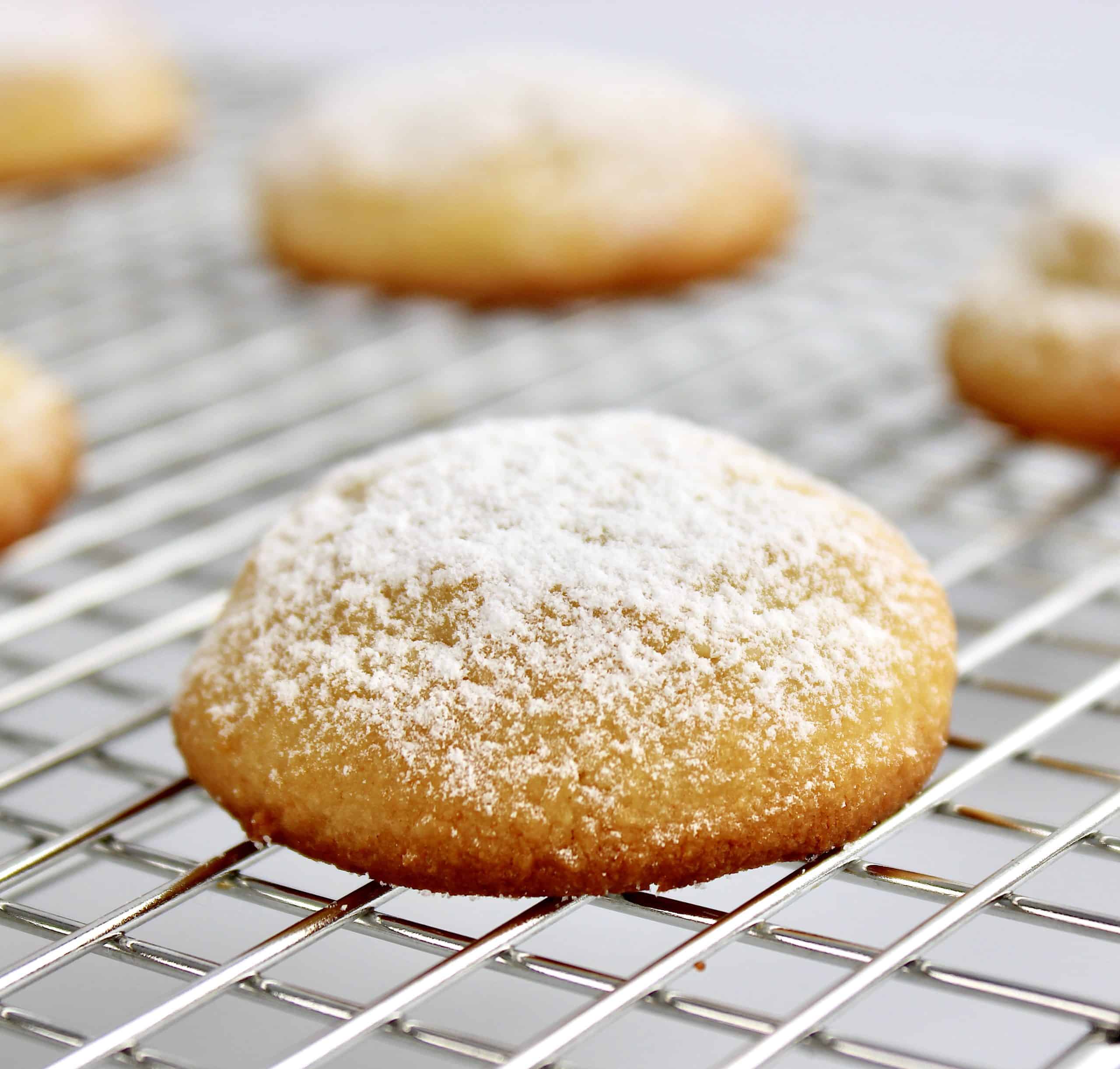 cream cheese cookies on cooling rack with powdered sugar on top