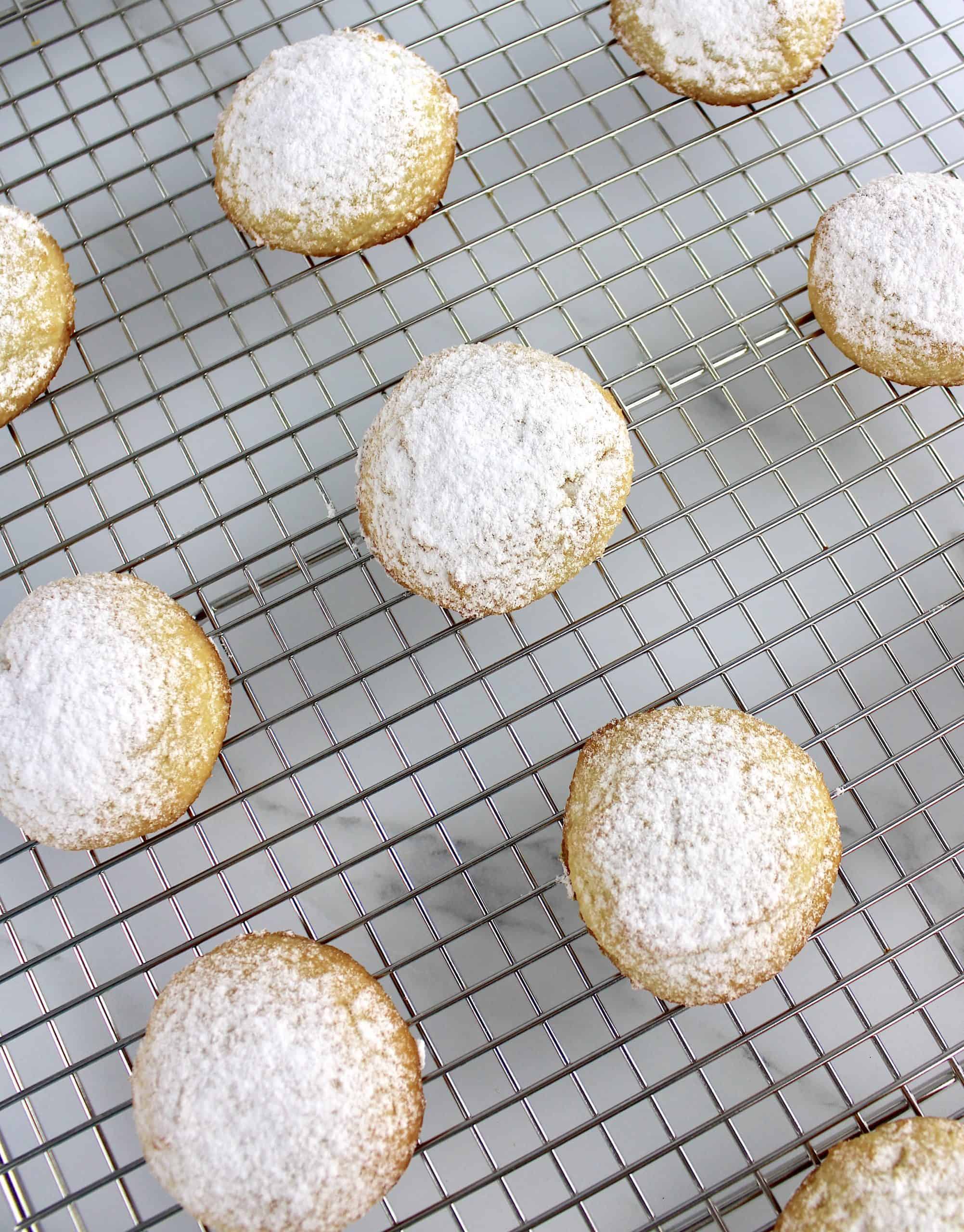overhead view of cookies with powdered sugar on top on baking rack