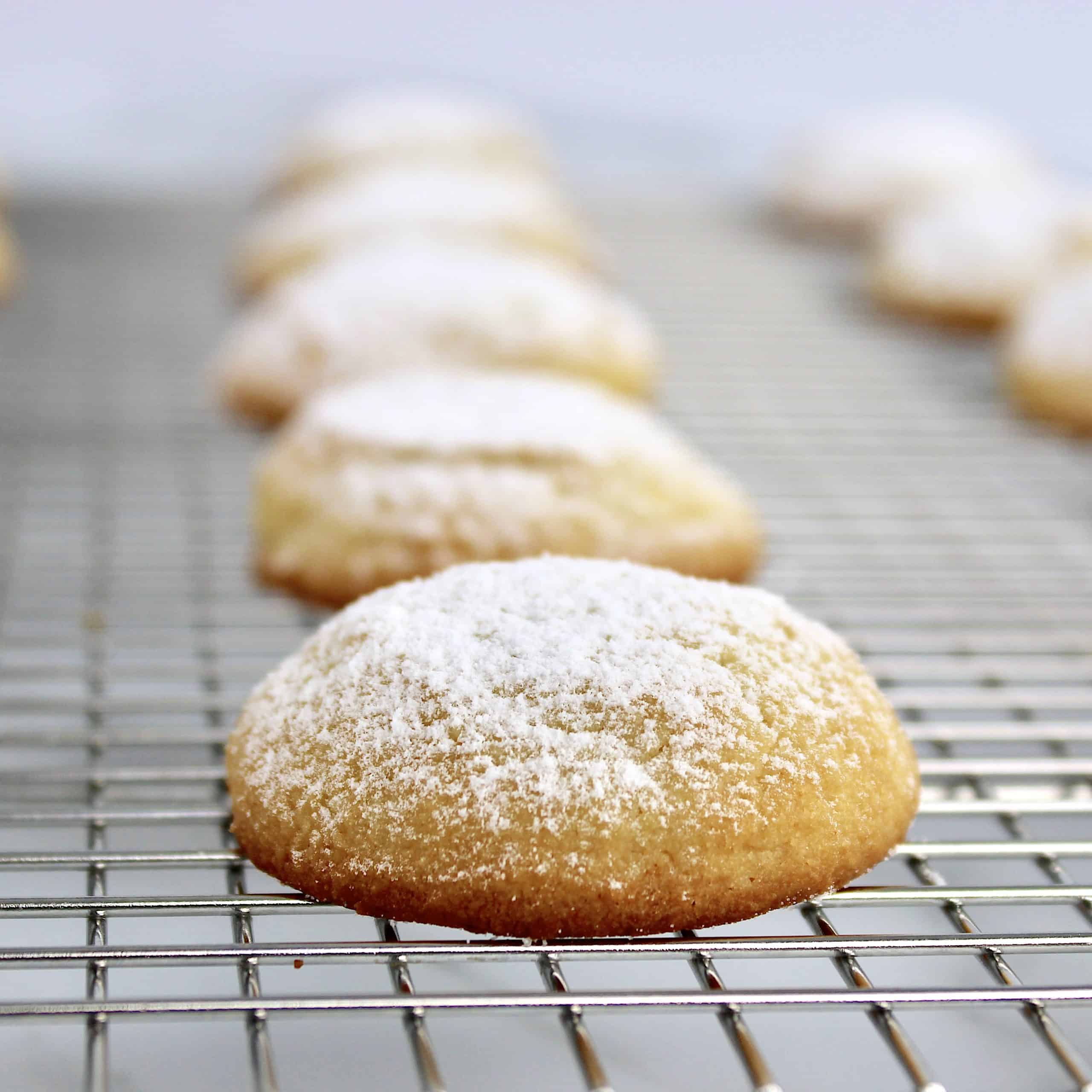 cream cheese cookies on cooling rack with powdered sugar on top