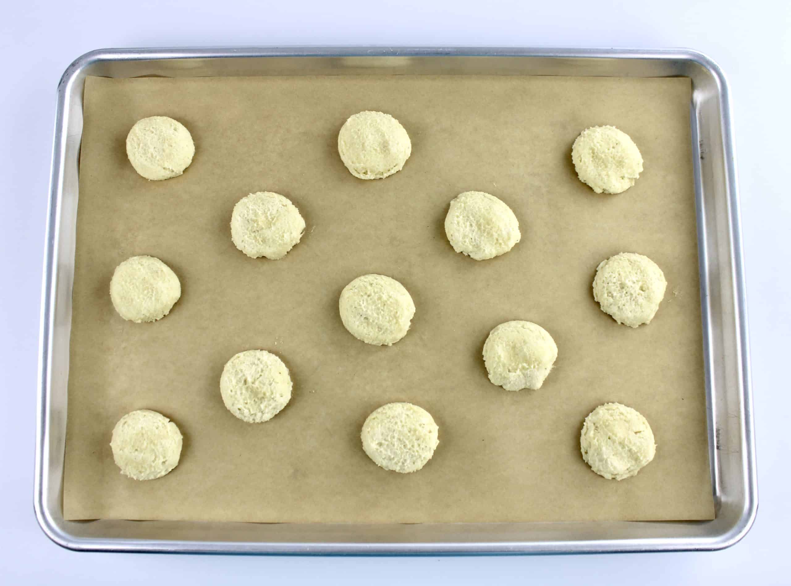 cookie dough balls unbaked on baking sheet with parchment paper
