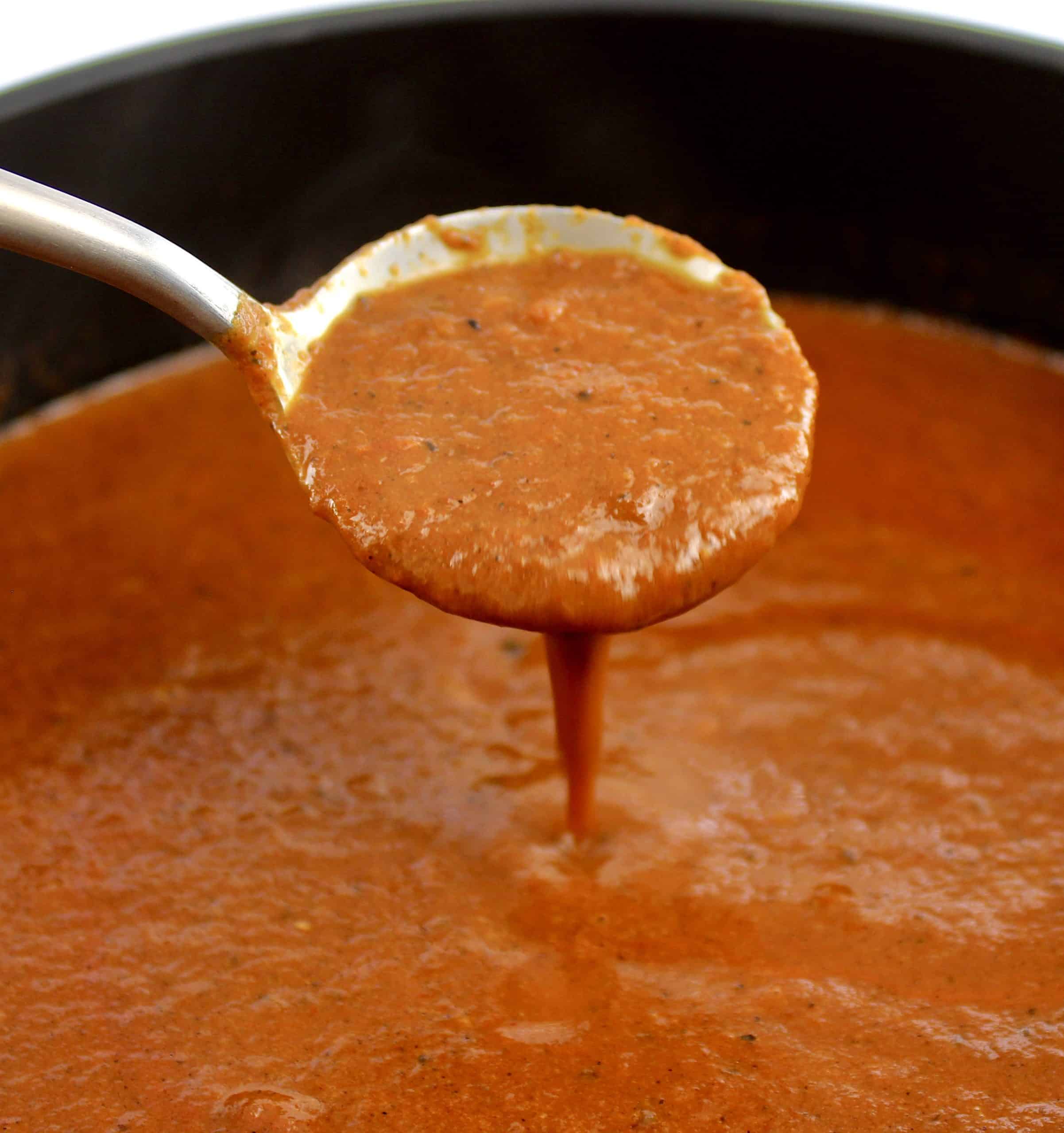 Keto Enchilada Sauce being spooned out of saucepan