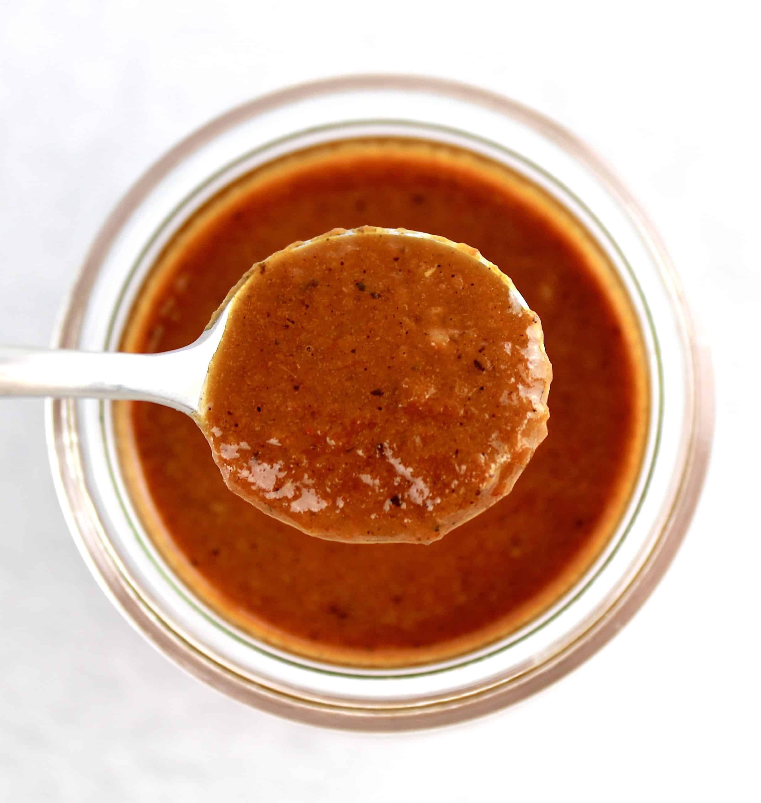 Keto Enchilada Sauce in spoon over glass jar