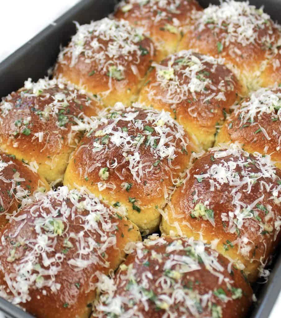 keto garlic rolls in pan with grated parmesan on top