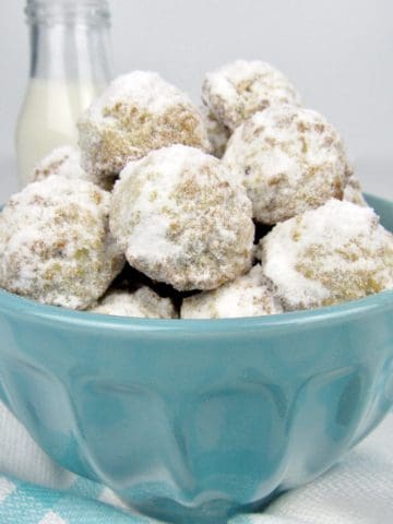 side view of snowball cookies in blue bowl