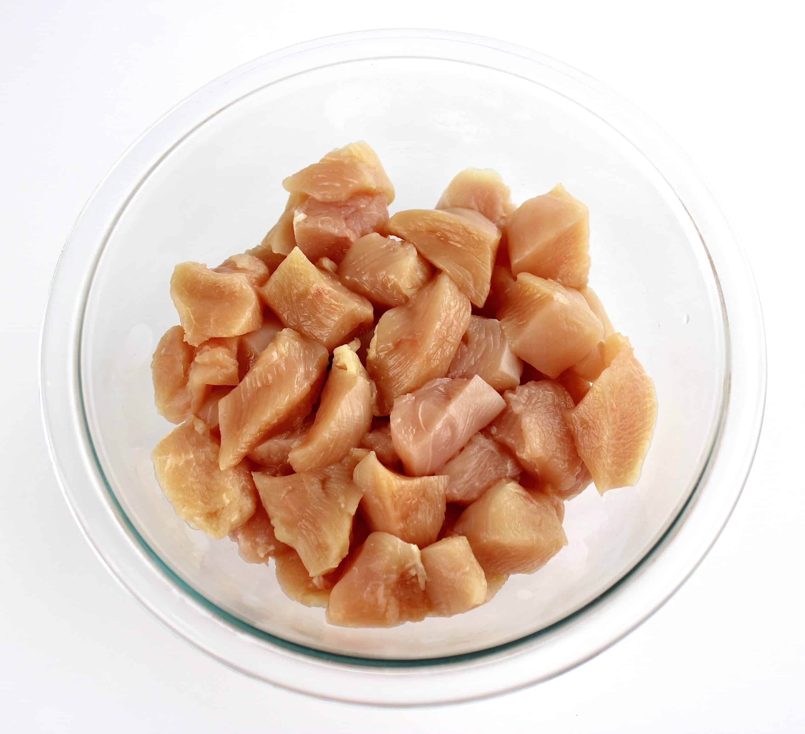 chunks of raw chicken pieces in glass bowl