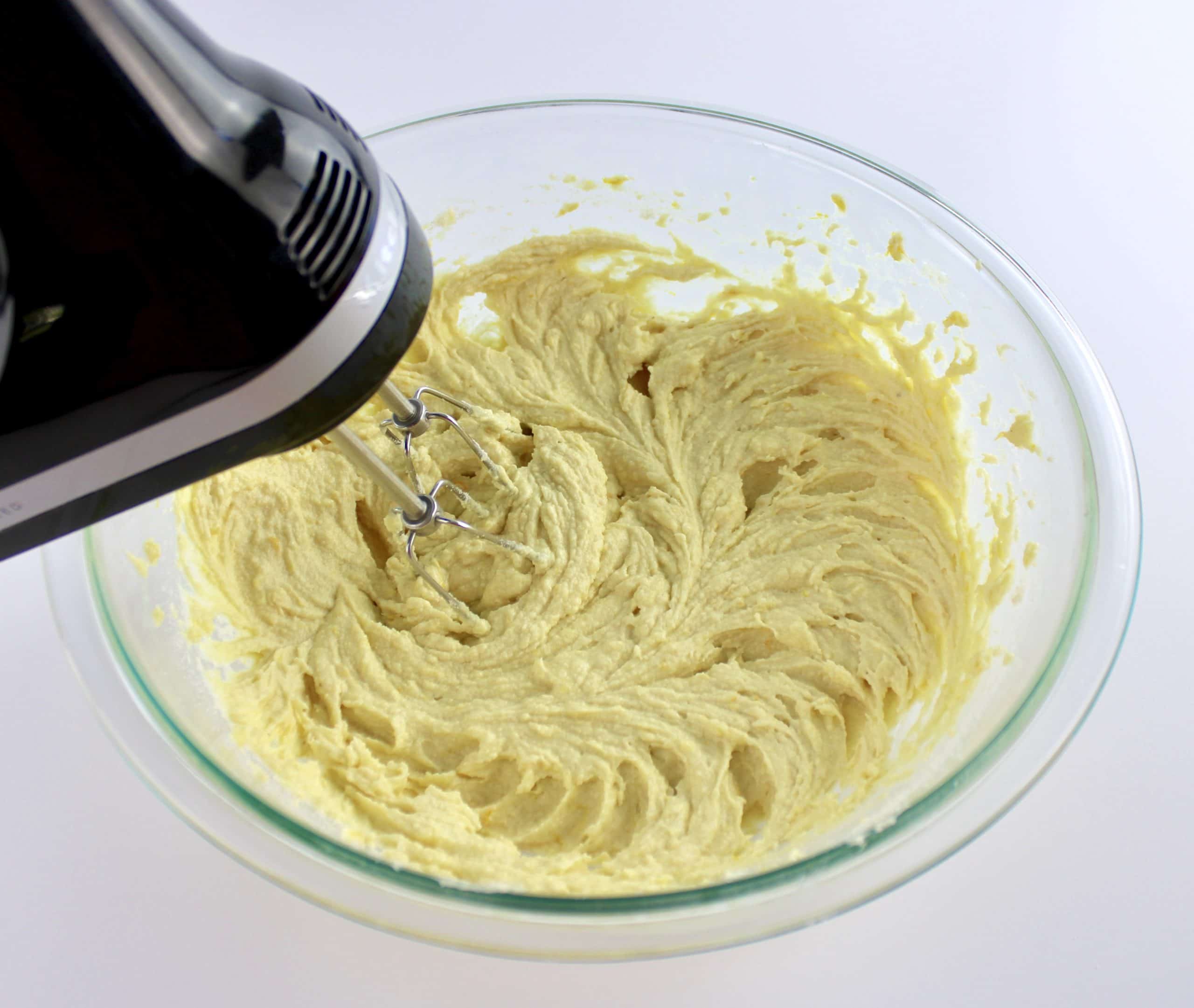 Orange pound cake batter being mixed with hand mixer