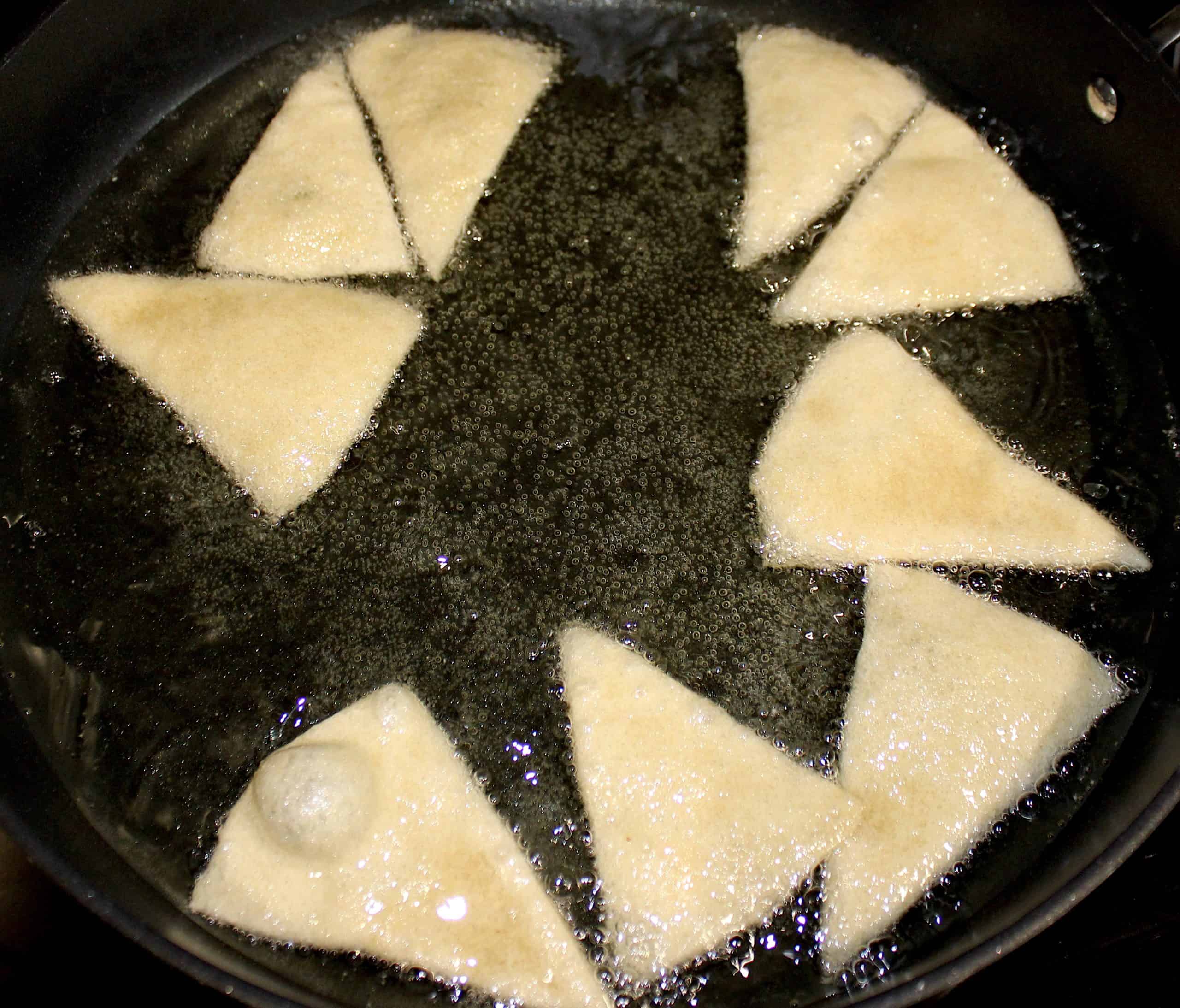 tortilla chips frying in skillet with oil