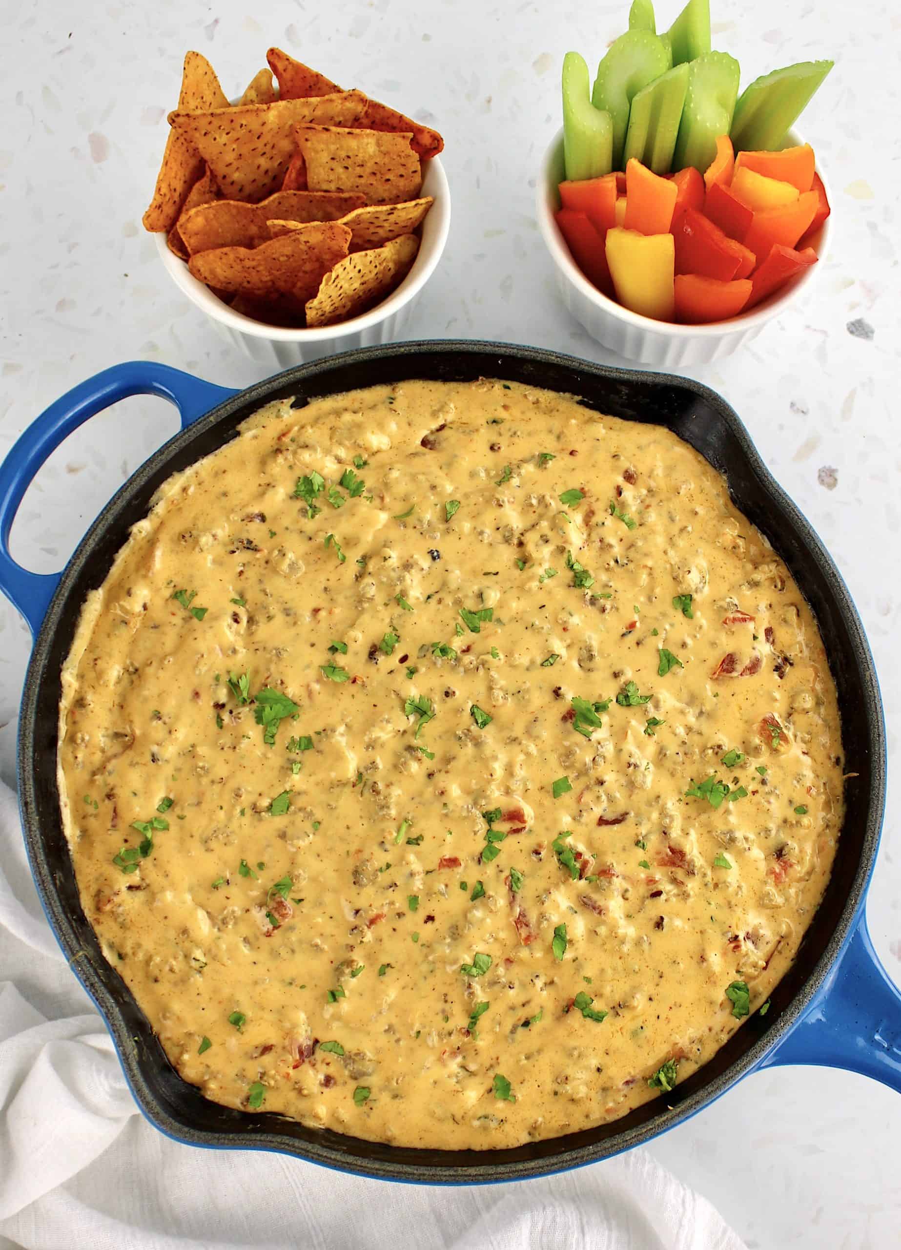 Sausage Rotel Dip in skillet with tortilla chips and pepper slices on side