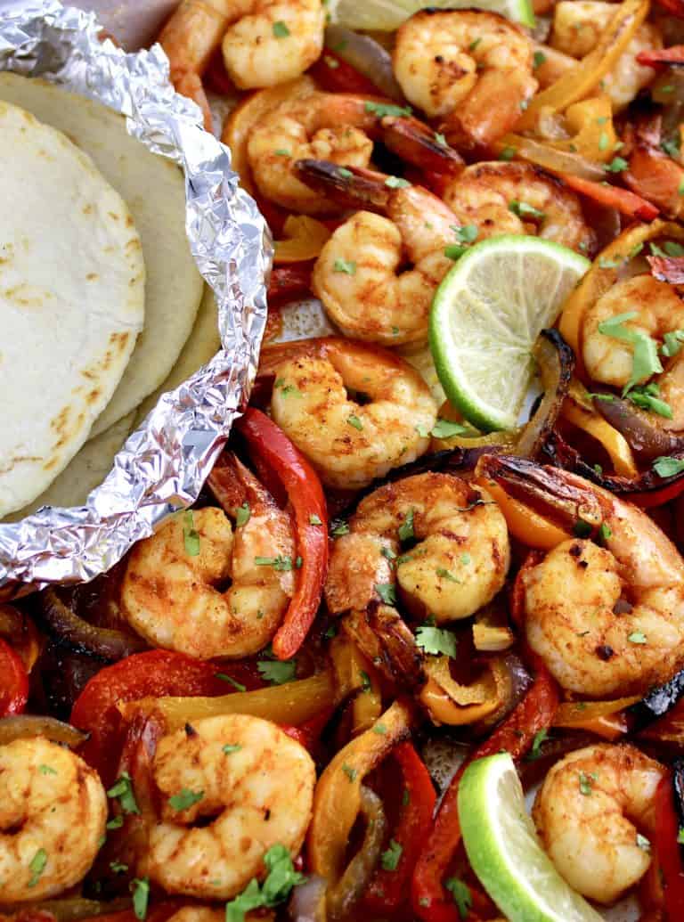 Sheet Pan Shrimp Fajitas with tortillas in foil on side
