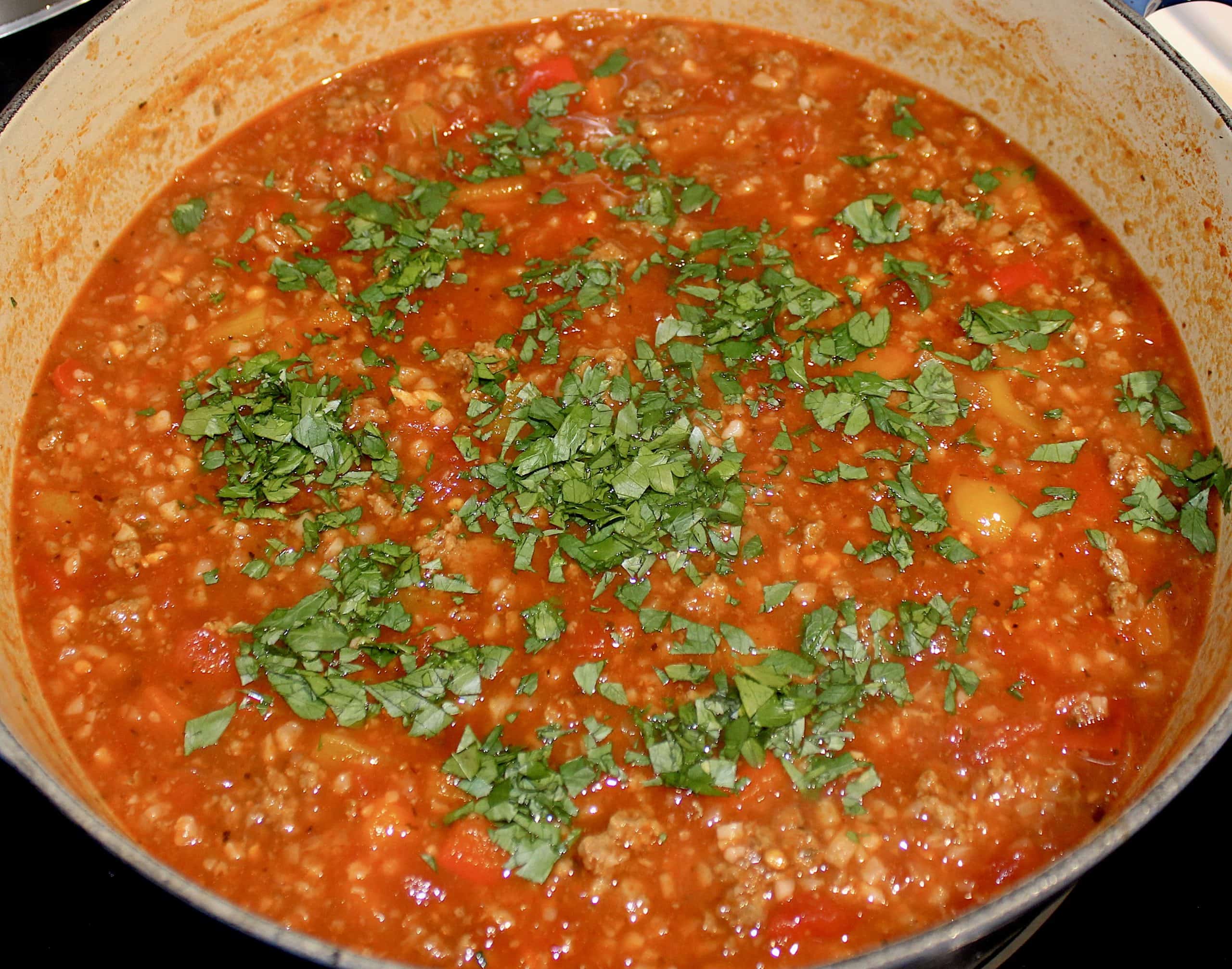 Stuffed Pepper Soup with chopped parsley on top in pot