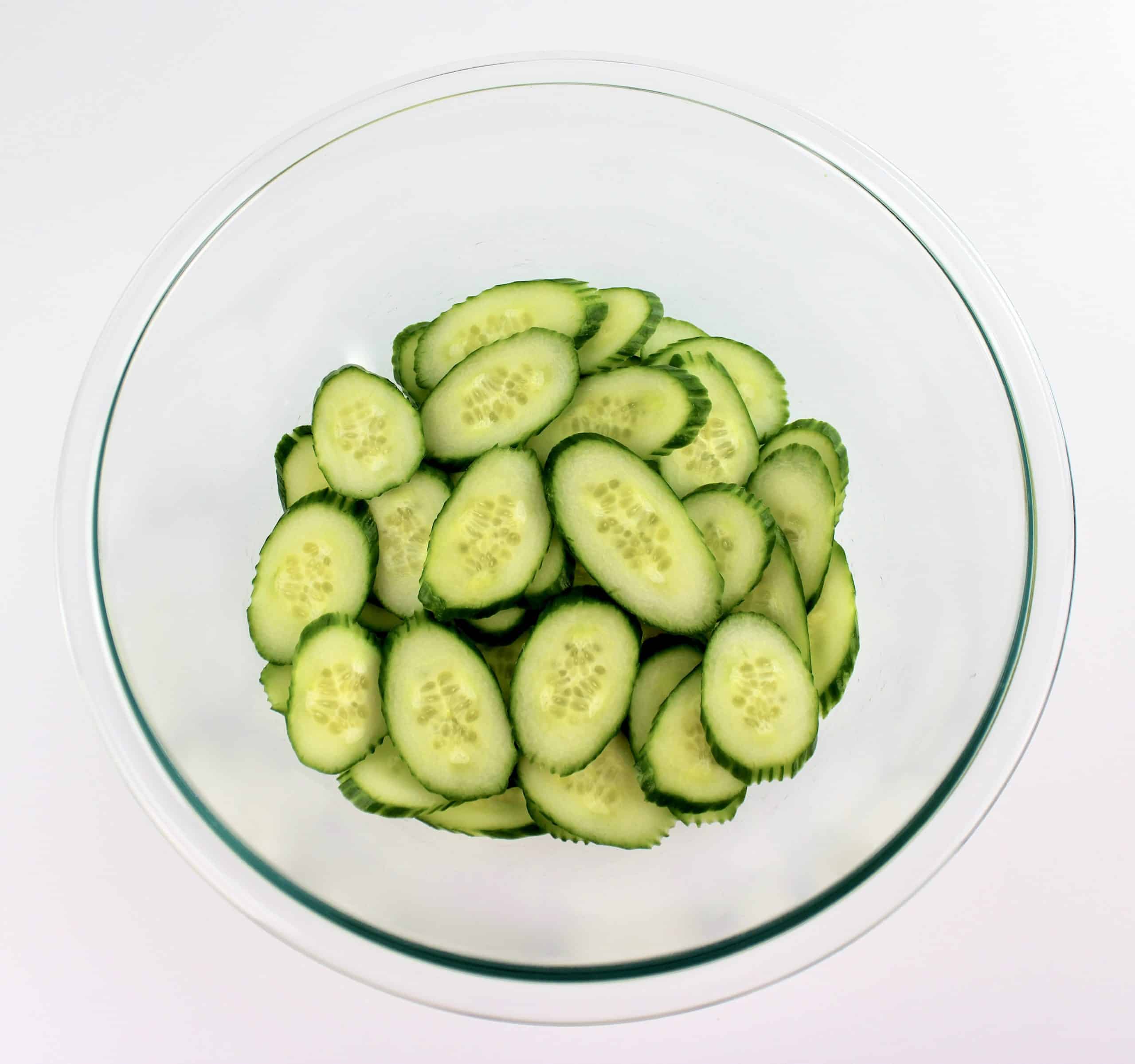 glass bowl with sliced cucumbers