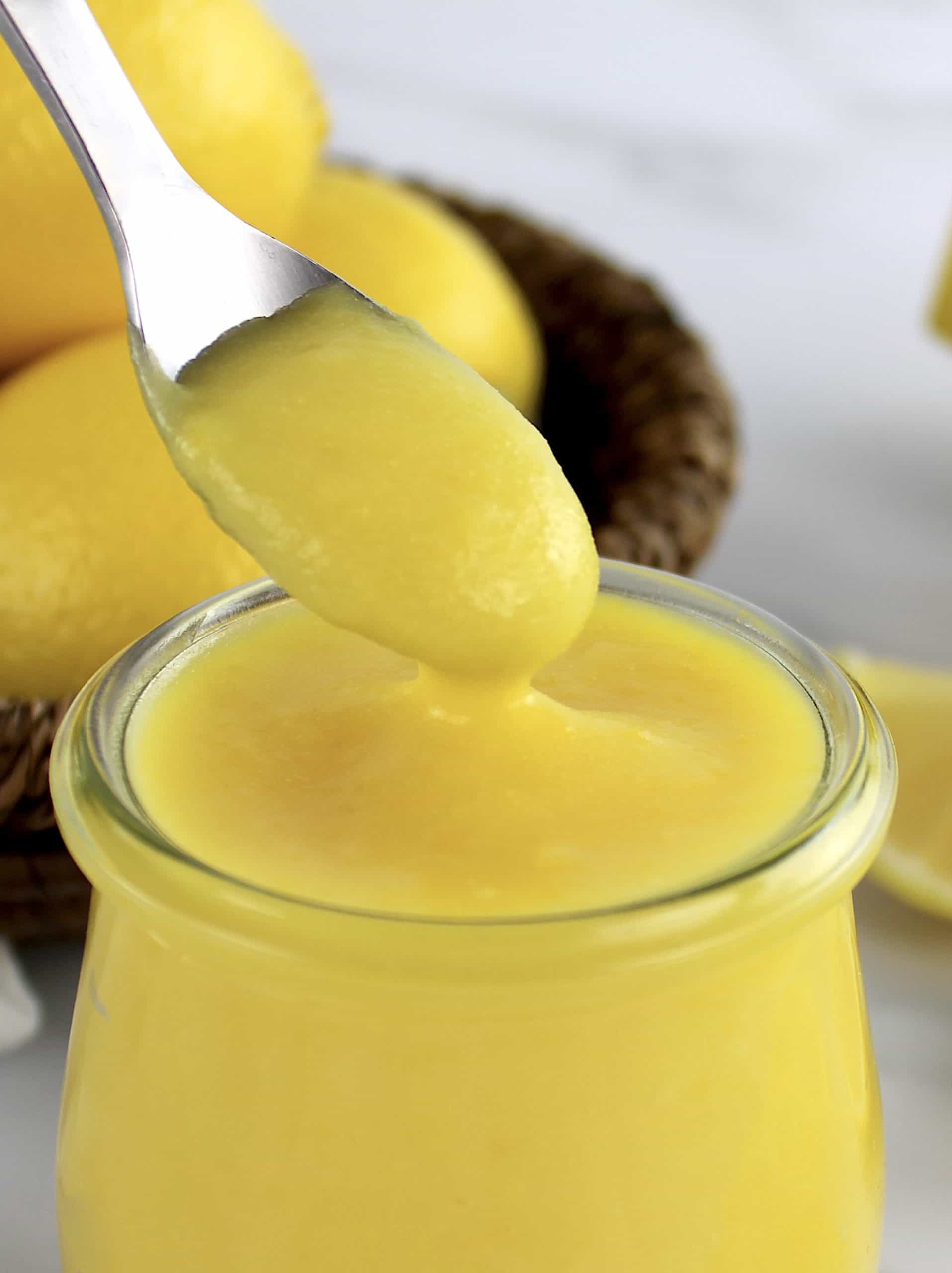 5 Minute Keto Lemon Curd in open glass jar with spoon holding up some