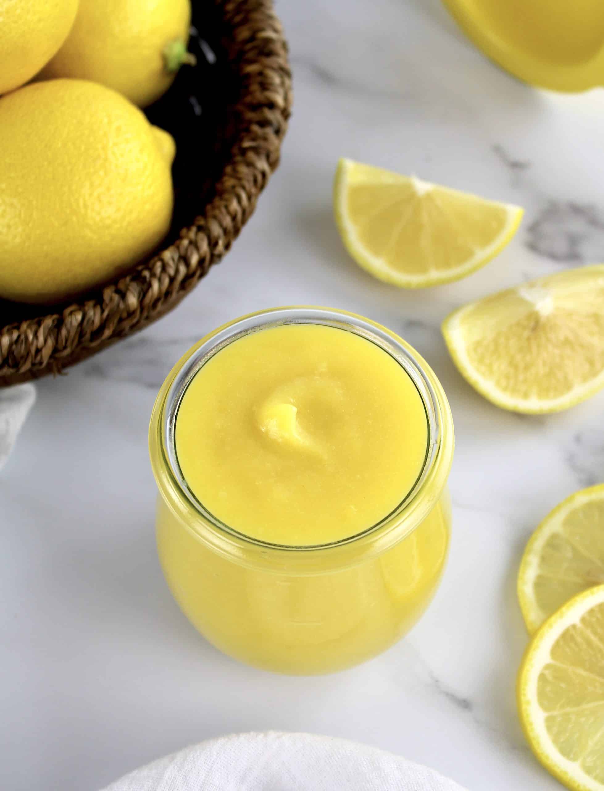 5 Minute Keto Lemon Curd in glass jar with lemon slices and whole lemons in background