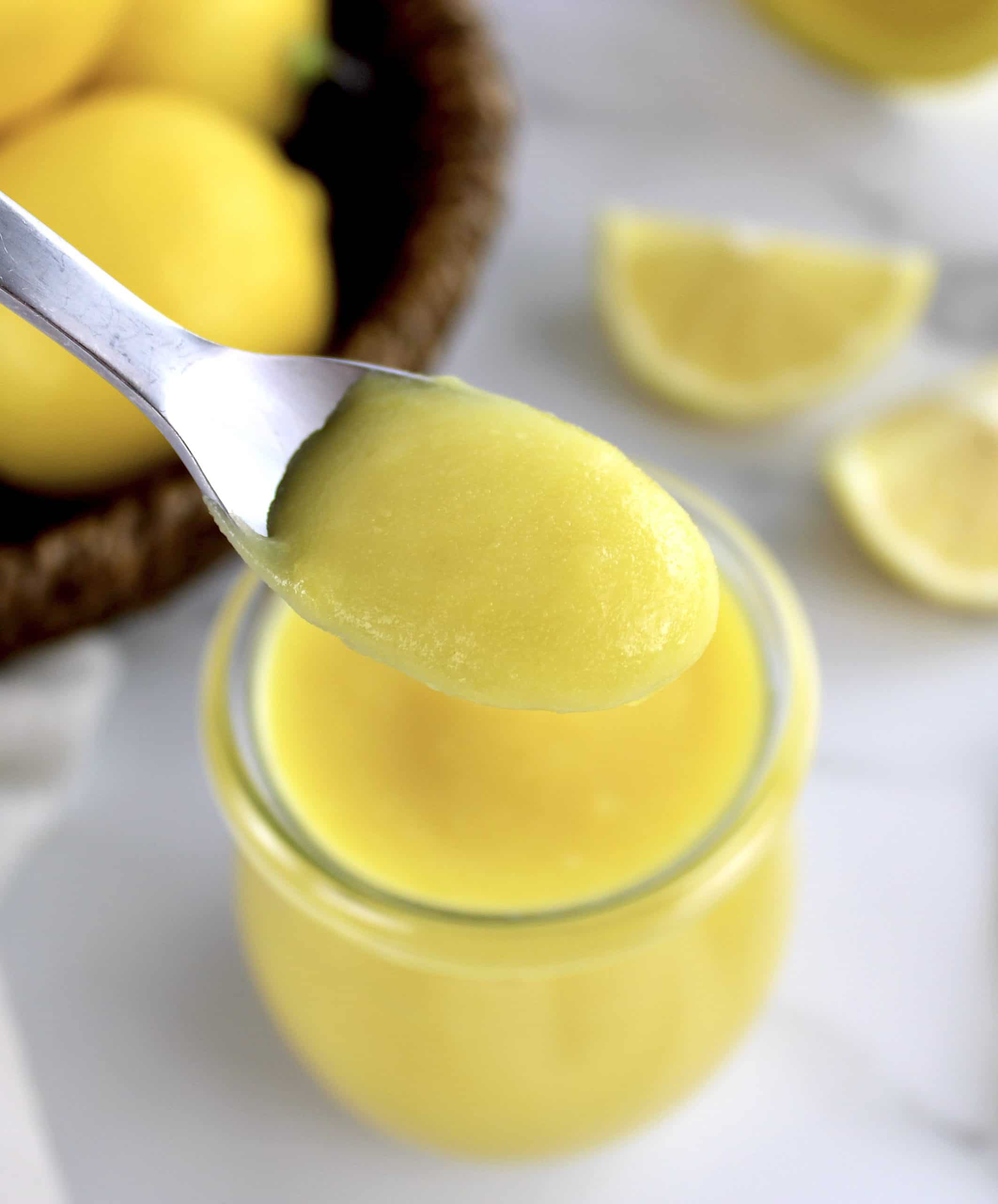 5 Minute Keto Lemon Curd in spoon held up over glass jar