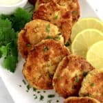 chicken patties with lemon slices on white plate with parsley garnish
