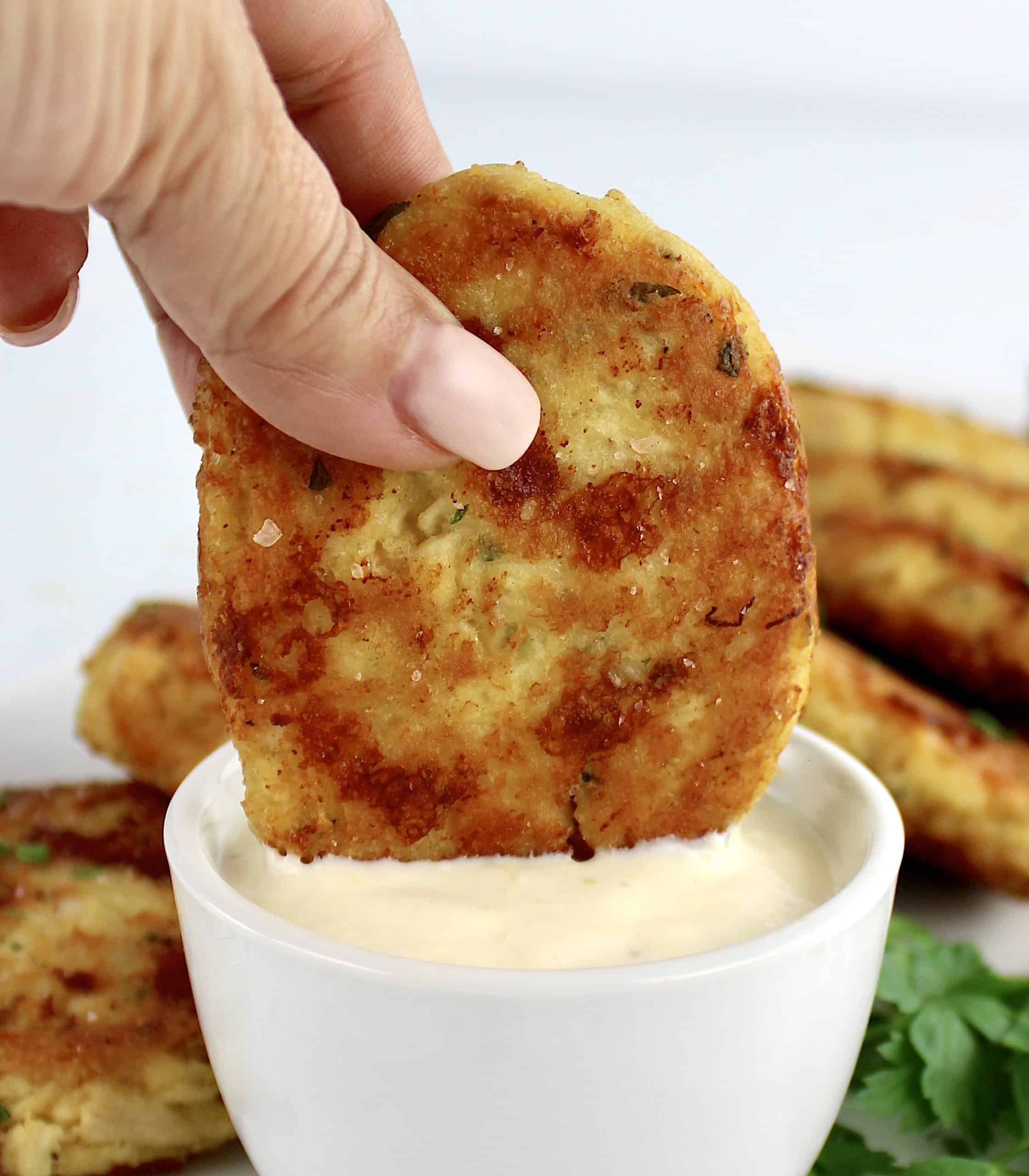 chicken pattie being dipped into sauce