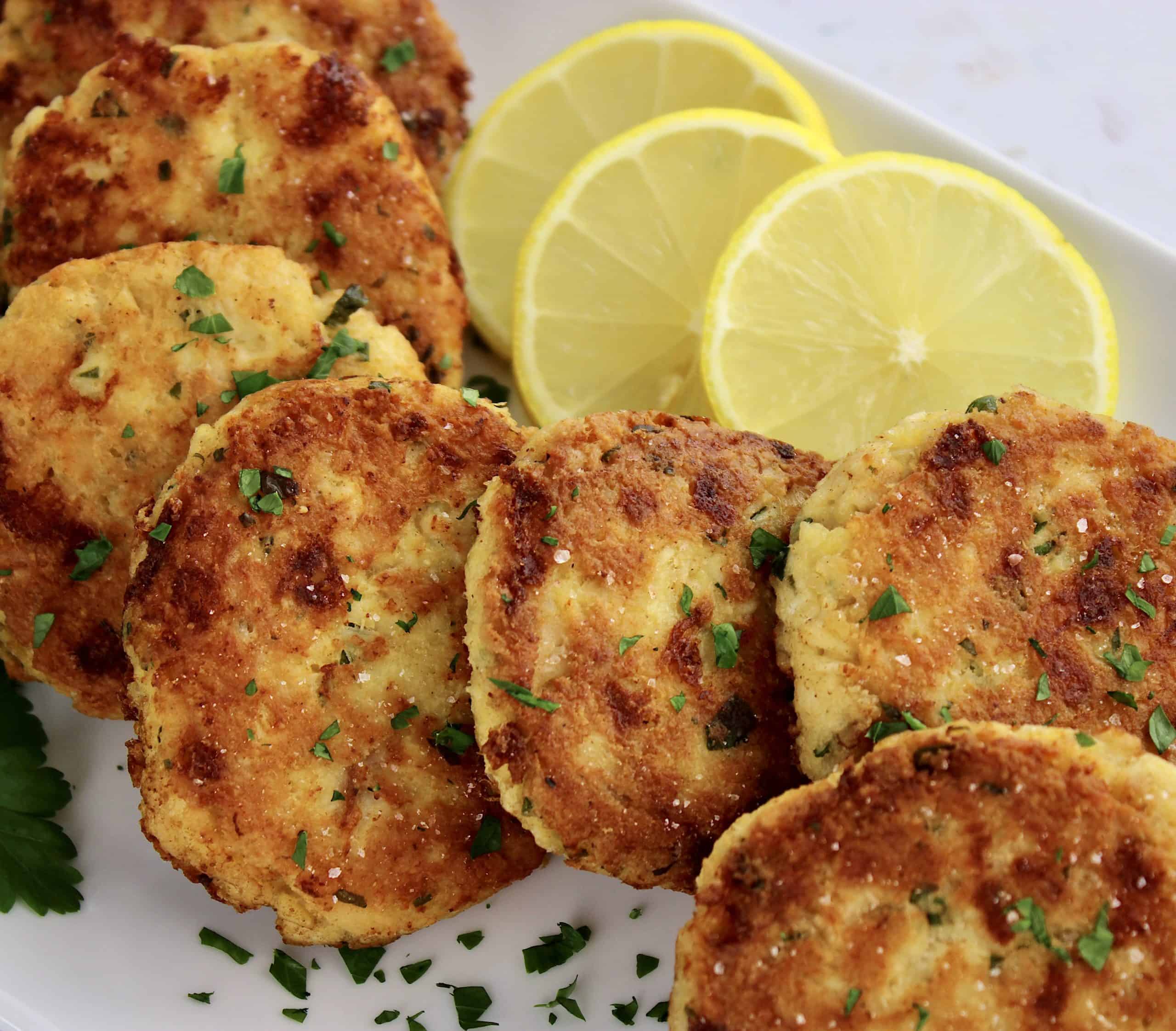 chicken patties on white plate with lemon slices on side