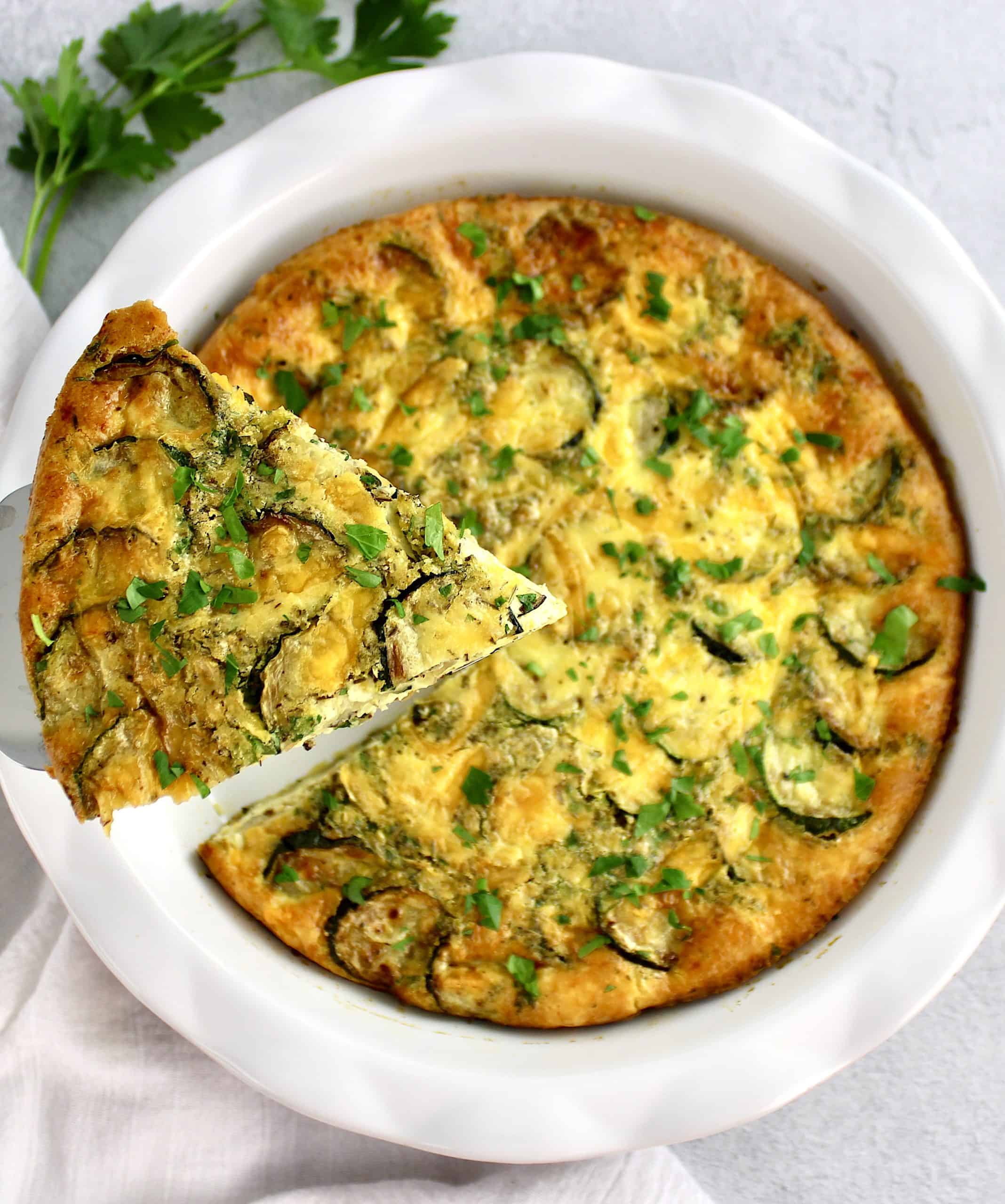 Crustless Zucchini Quiche with slice being held up