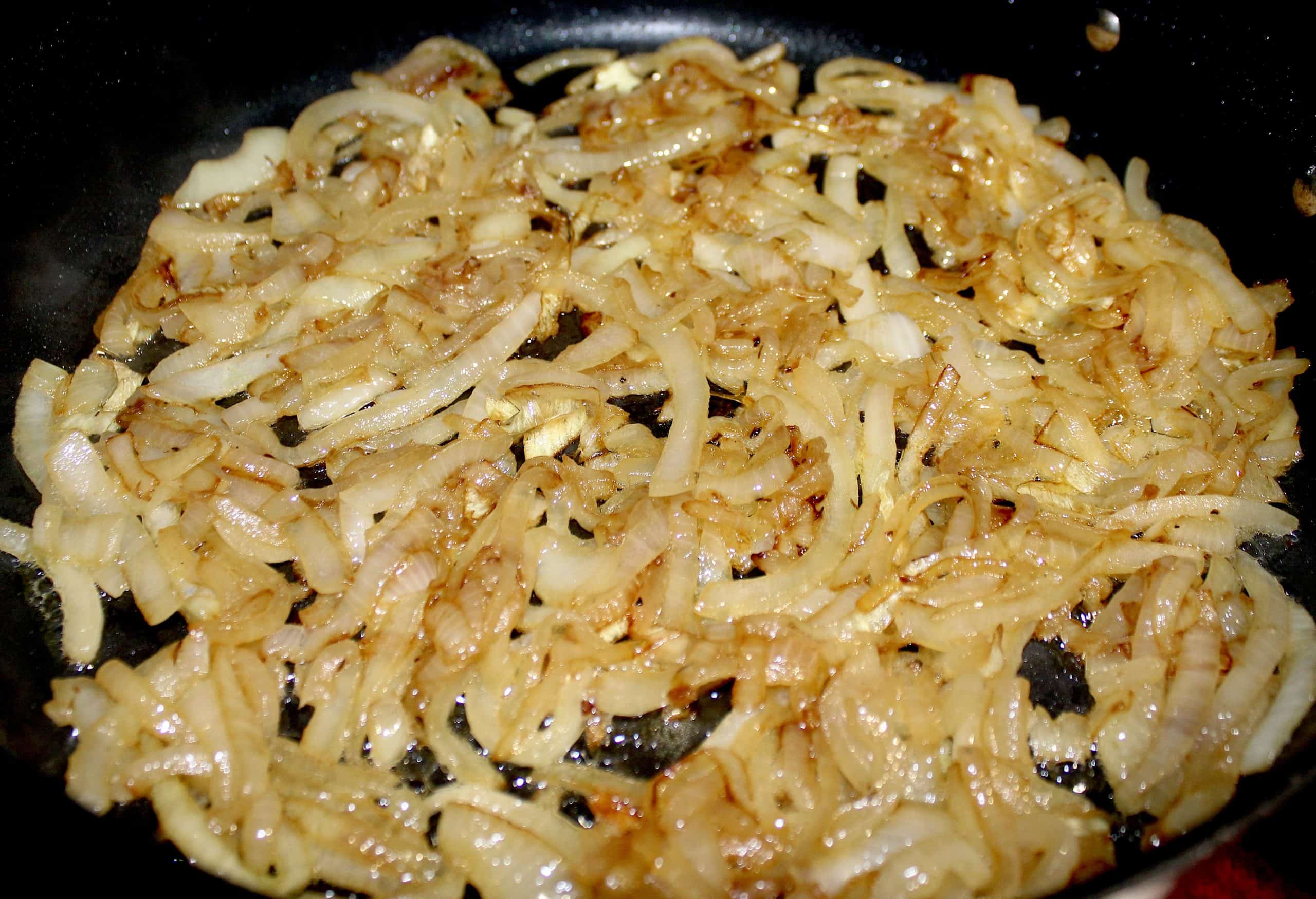 sliced onions cooking in skillet