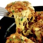 French Onion Chicken piece being held up by spatula