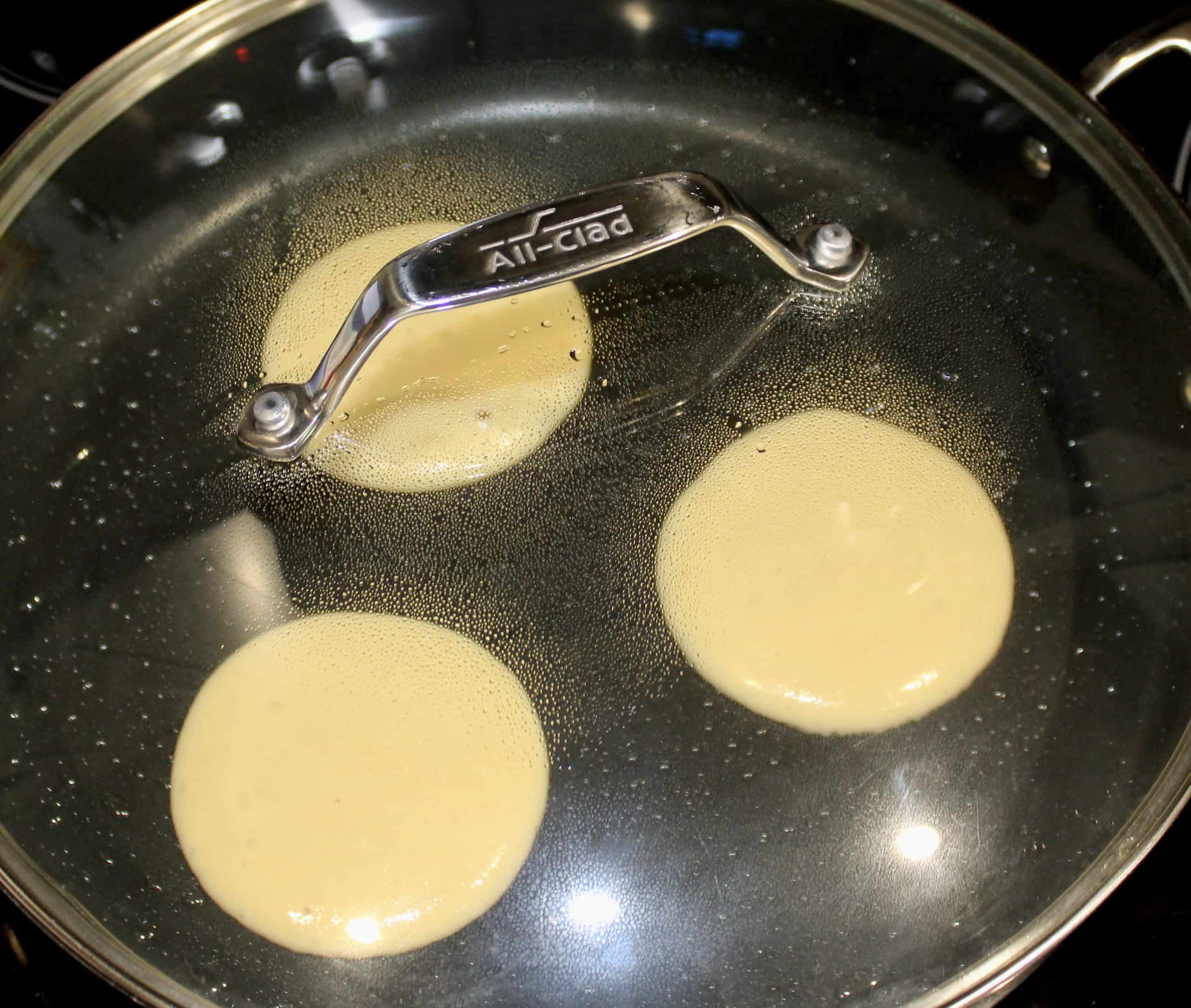 3 pancakes in skillet with lid