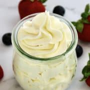 Keto Cheesecake Fluff in glass jar with berries in background