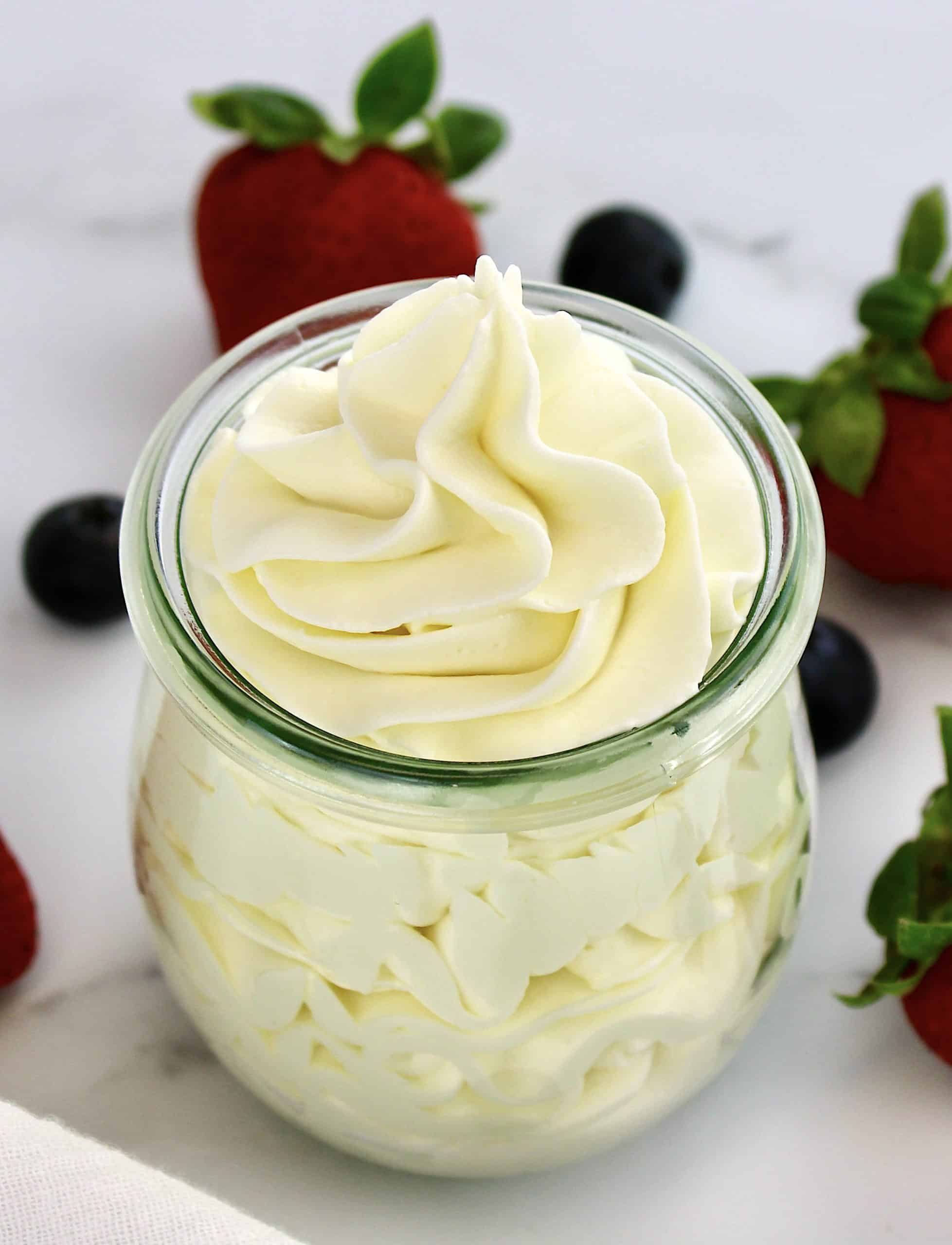 Keto Cheesecake Fluff in glass jar with berries in background
