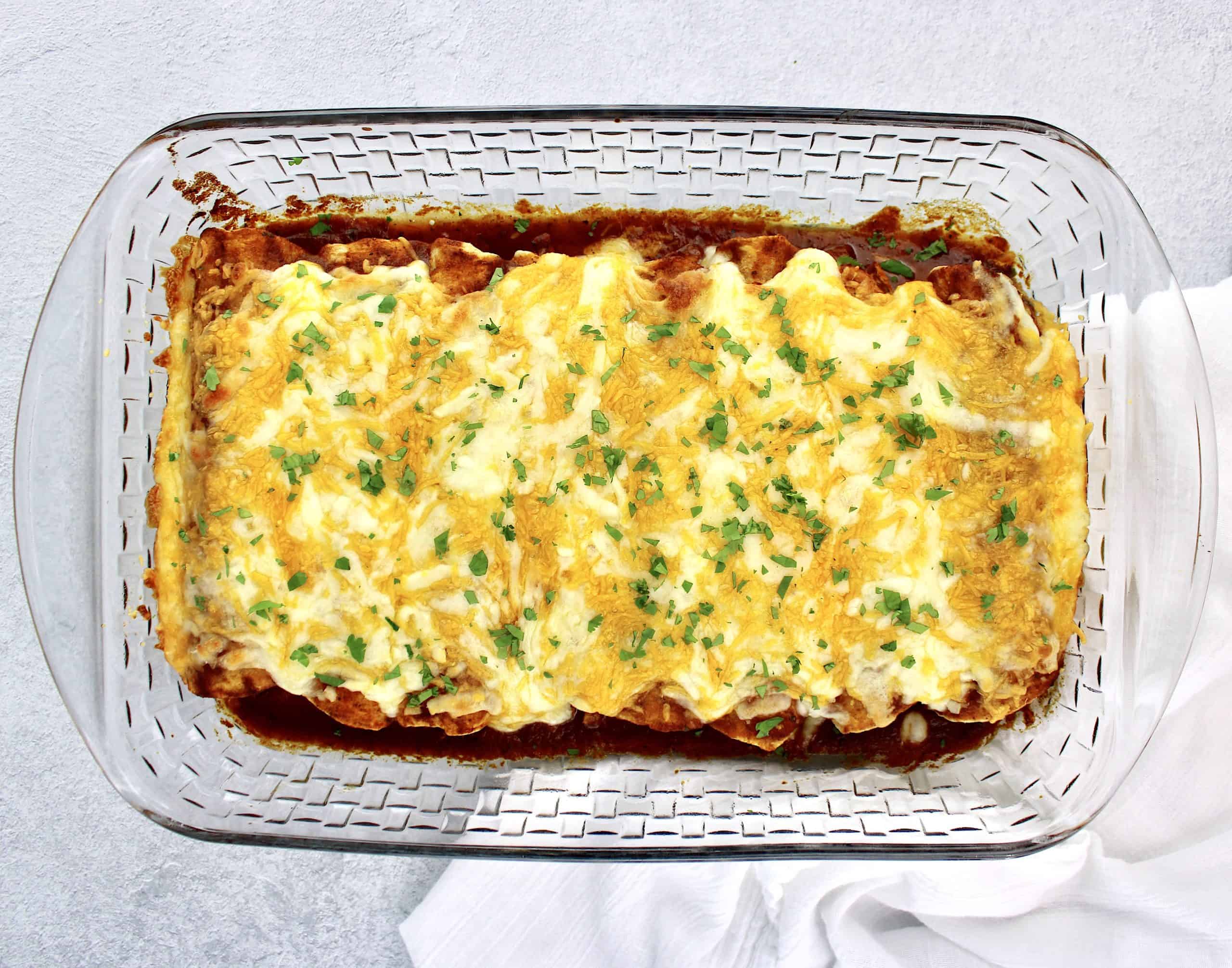 8 Keto Chicken Enchiladas baked with cheese on top with chopped cilantro garnish