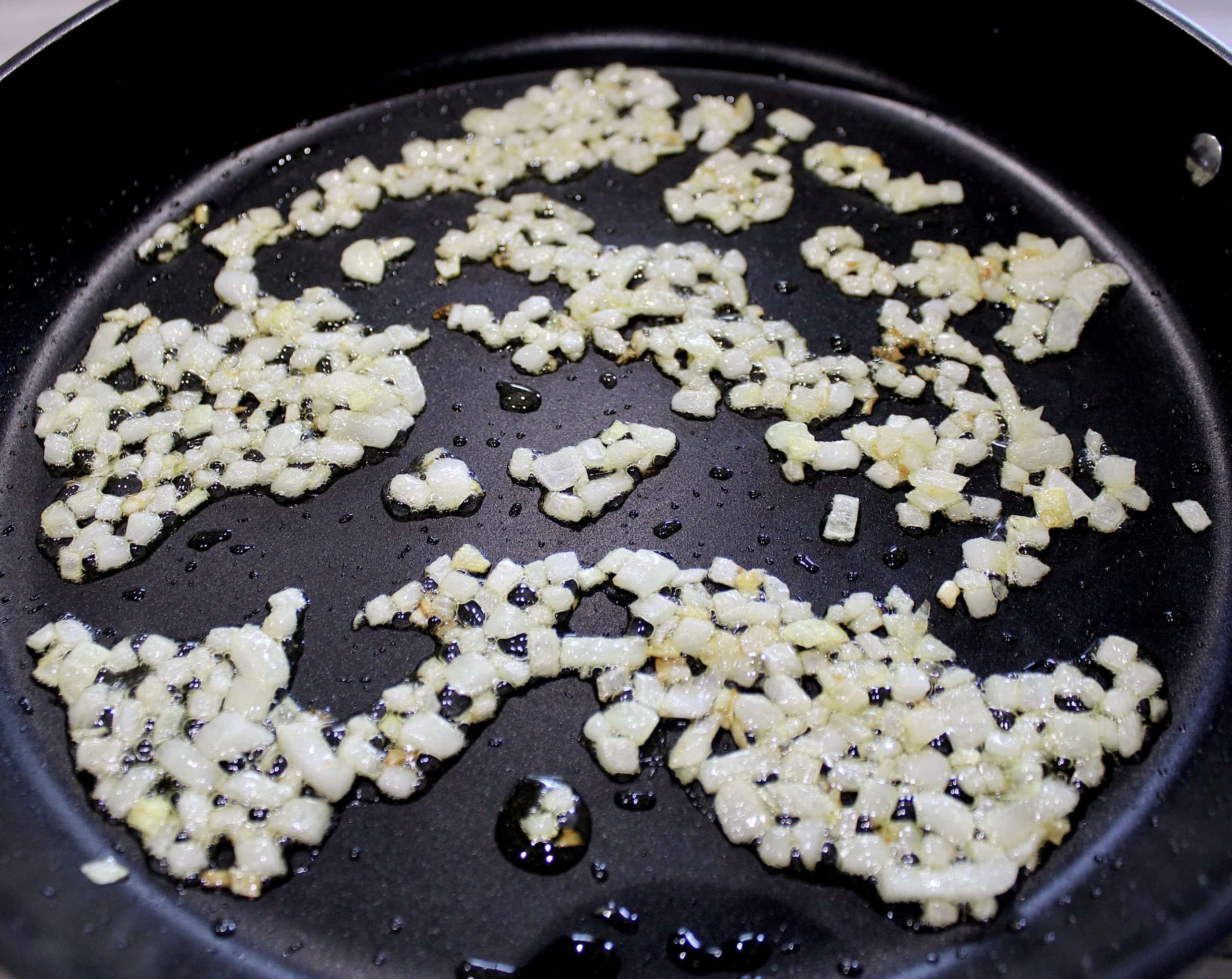 diced onions sautéing in skillet