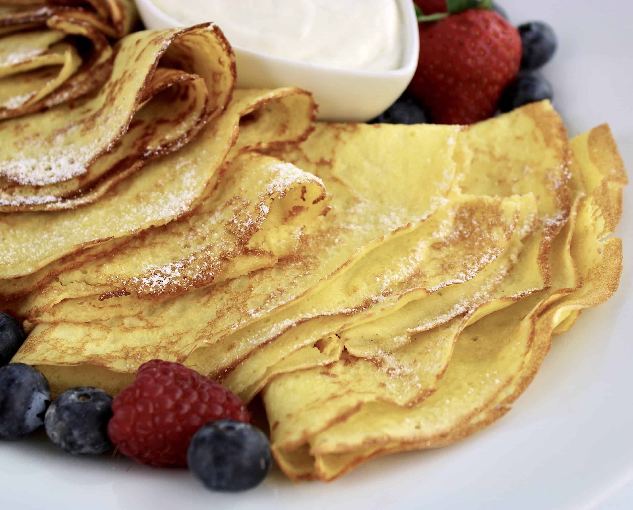 closeup of folder crepes on plate with berries