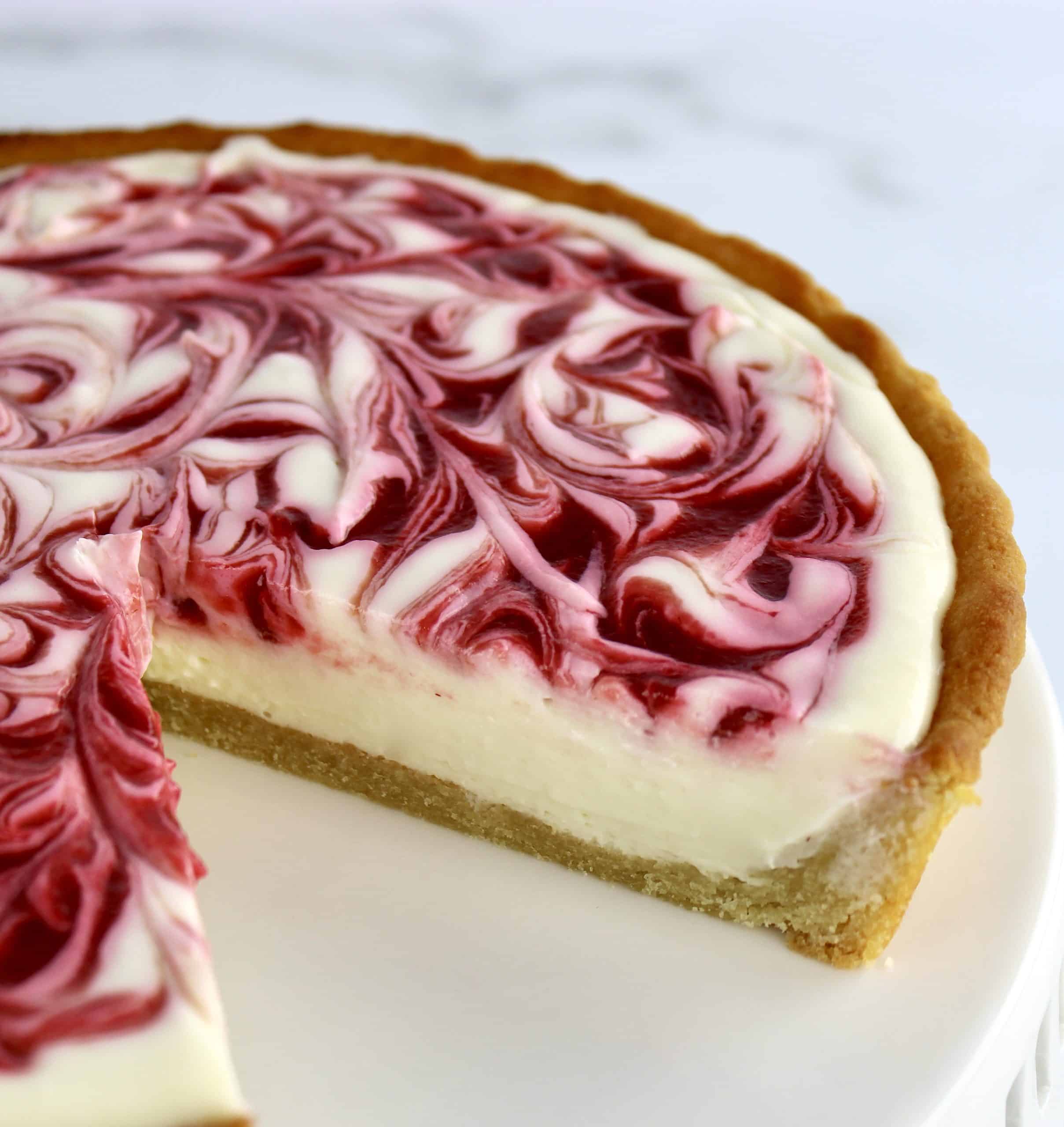 closeup of Keto White Chocolate Raspberry Cheesecake with slice missing