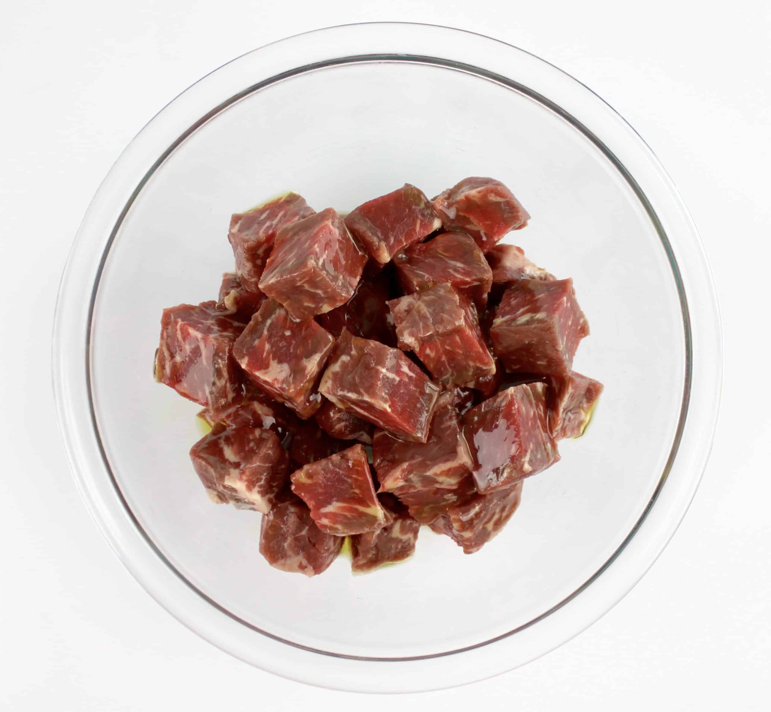 steak bites in glass bowl with olive oil on top